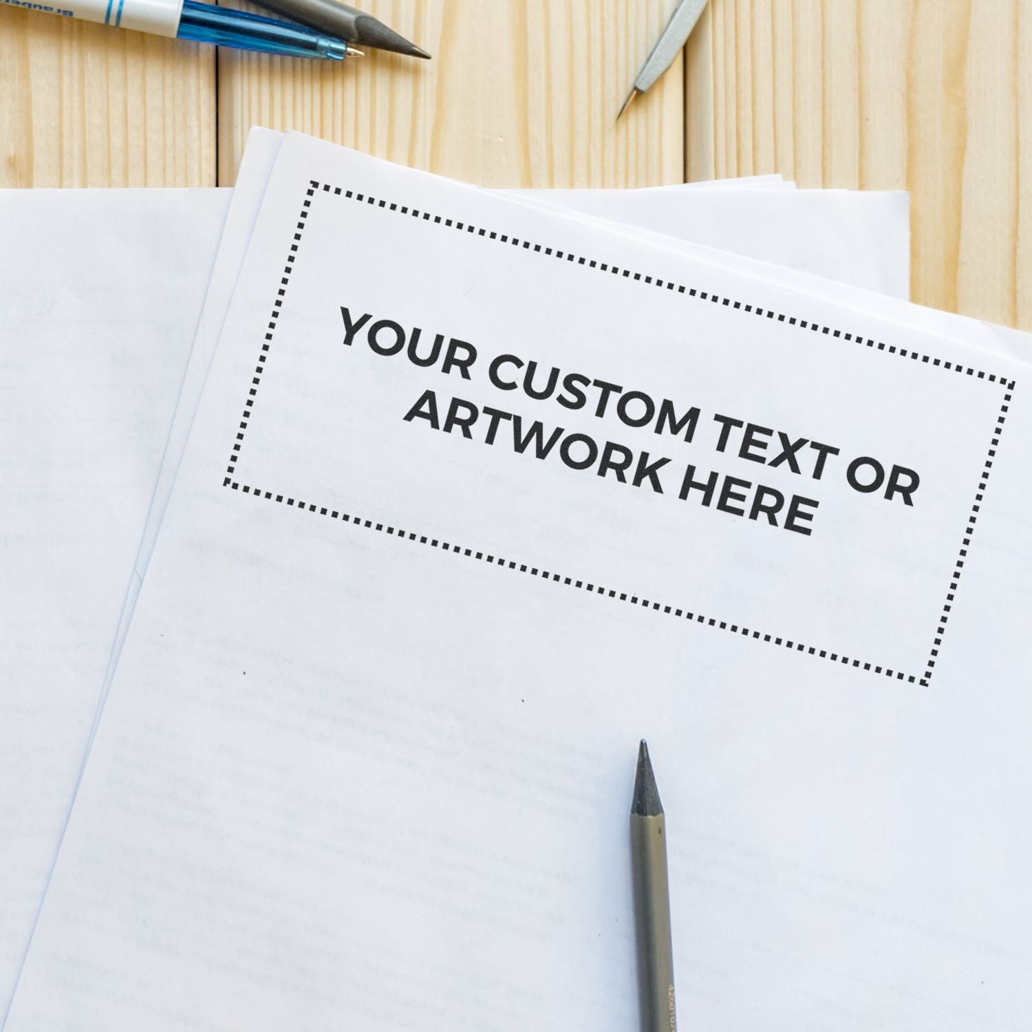 Custom Rubber Stamp Size 3 x 7 used on a white paper with the text YOUR CUSTOM TEXT OR ARTWORK HERE surrounded by pens on a wooden surface.