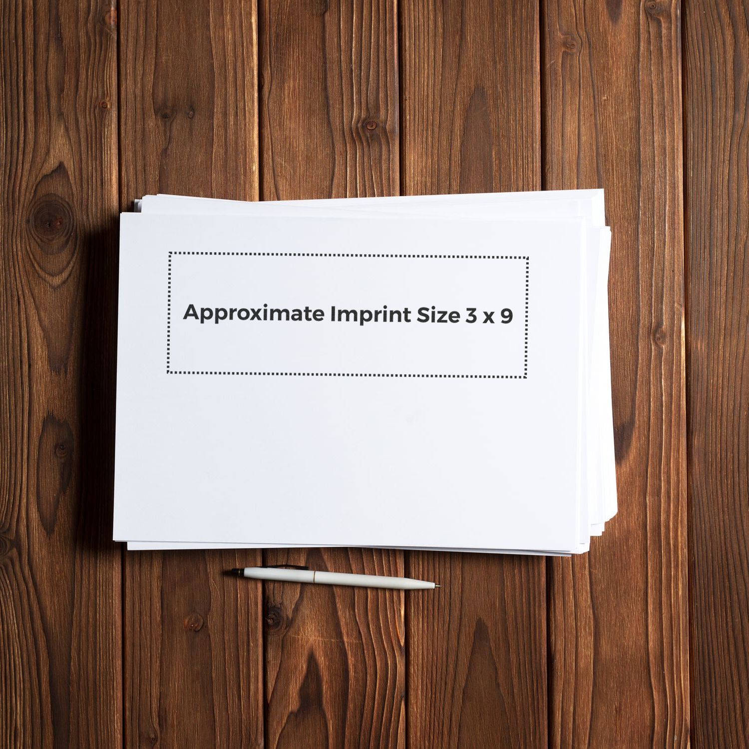 Custom Rubber Stamp Size 3 x 9 displayed on white paper with approximate imprint size, placed on a wooden surface with a pen nearby.