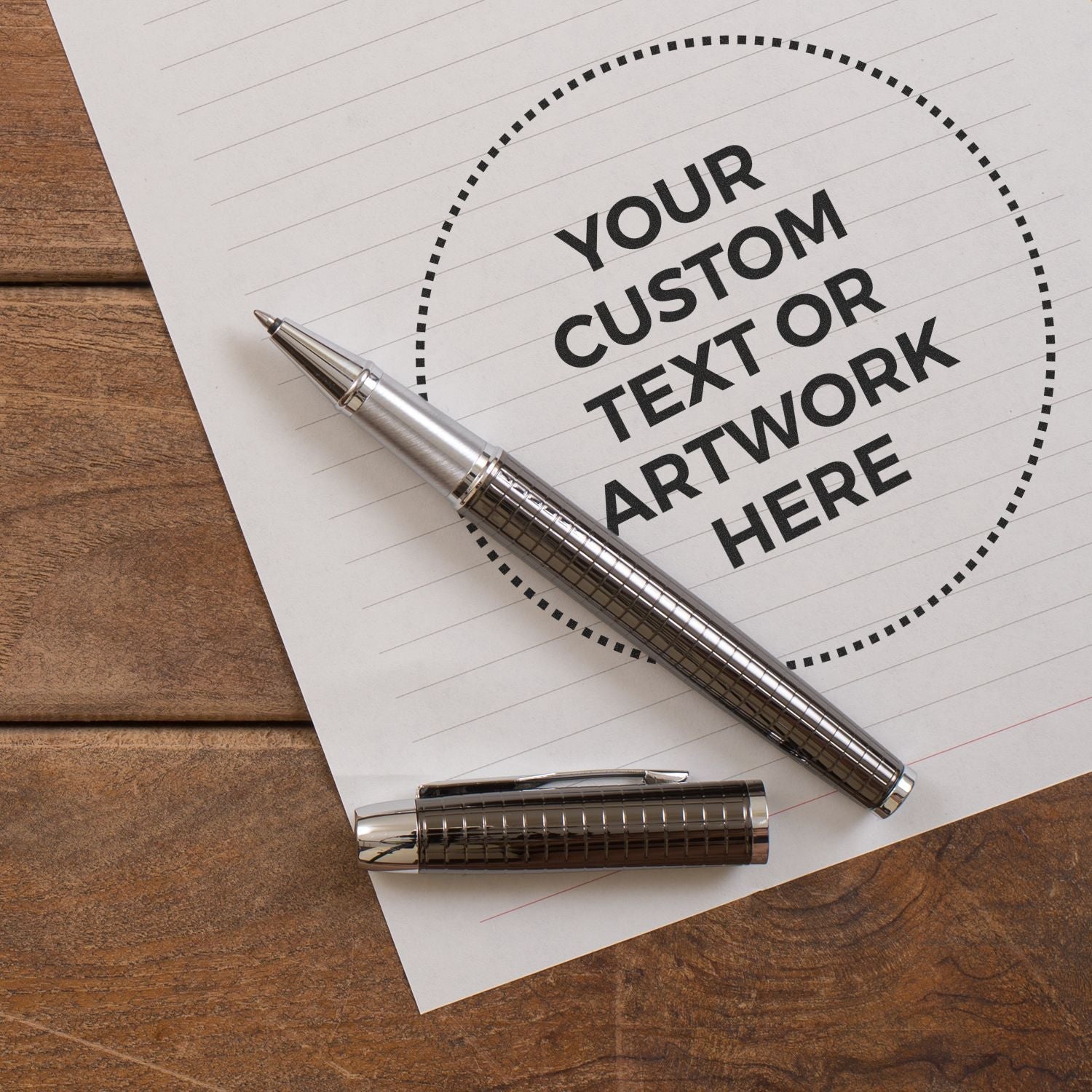 Custom Rubber Stamp Size 4 Inch Diameter stamped on paper with Your Custom Text or Artwork Here next to a silver pen on a wooden surface.