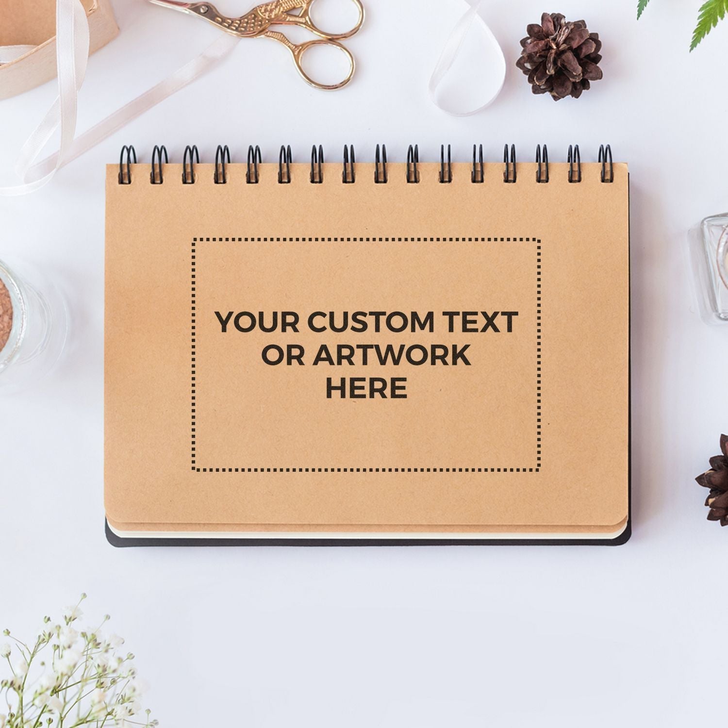 Custom Rubber Stamp Size 6 x 9 used on a brown spiral notebook with Your Custom Text or Artwork Here surrounded by crafting supplies.