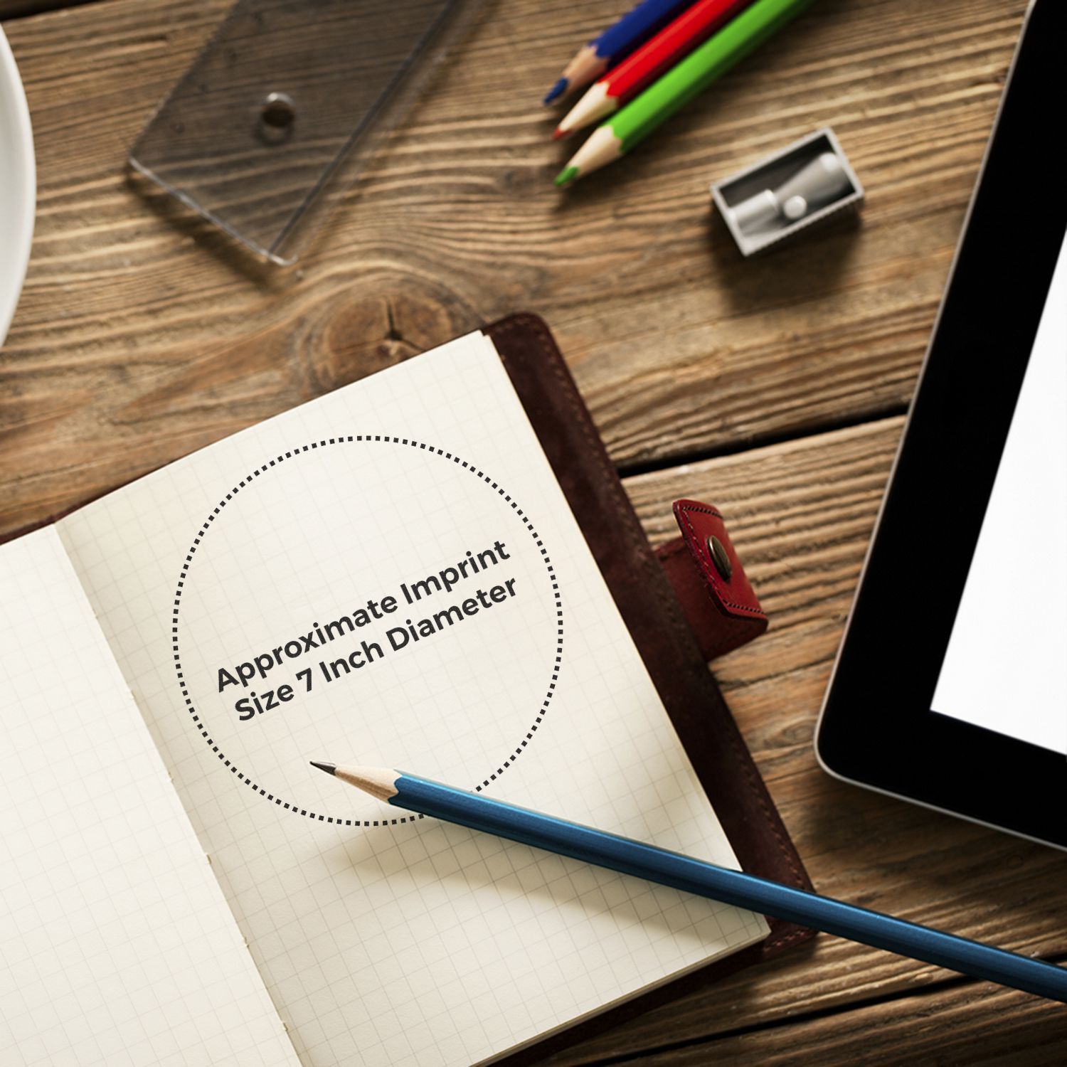 Notebook with Approximate Imprint Size 7 Inch Diameter text, Custom Rubber Stamp Size 7 Inch Diameter, pencil, and tablet on wooden desk.