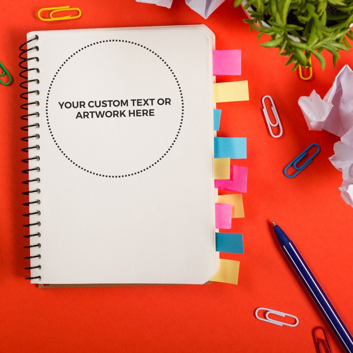 Notebook with colorful tabs and a stamped circle reading YOUR CUSTOM TEXT OR ARTWORK HERE using Custom Rubber Stamp Size 7 Inch Diameter.