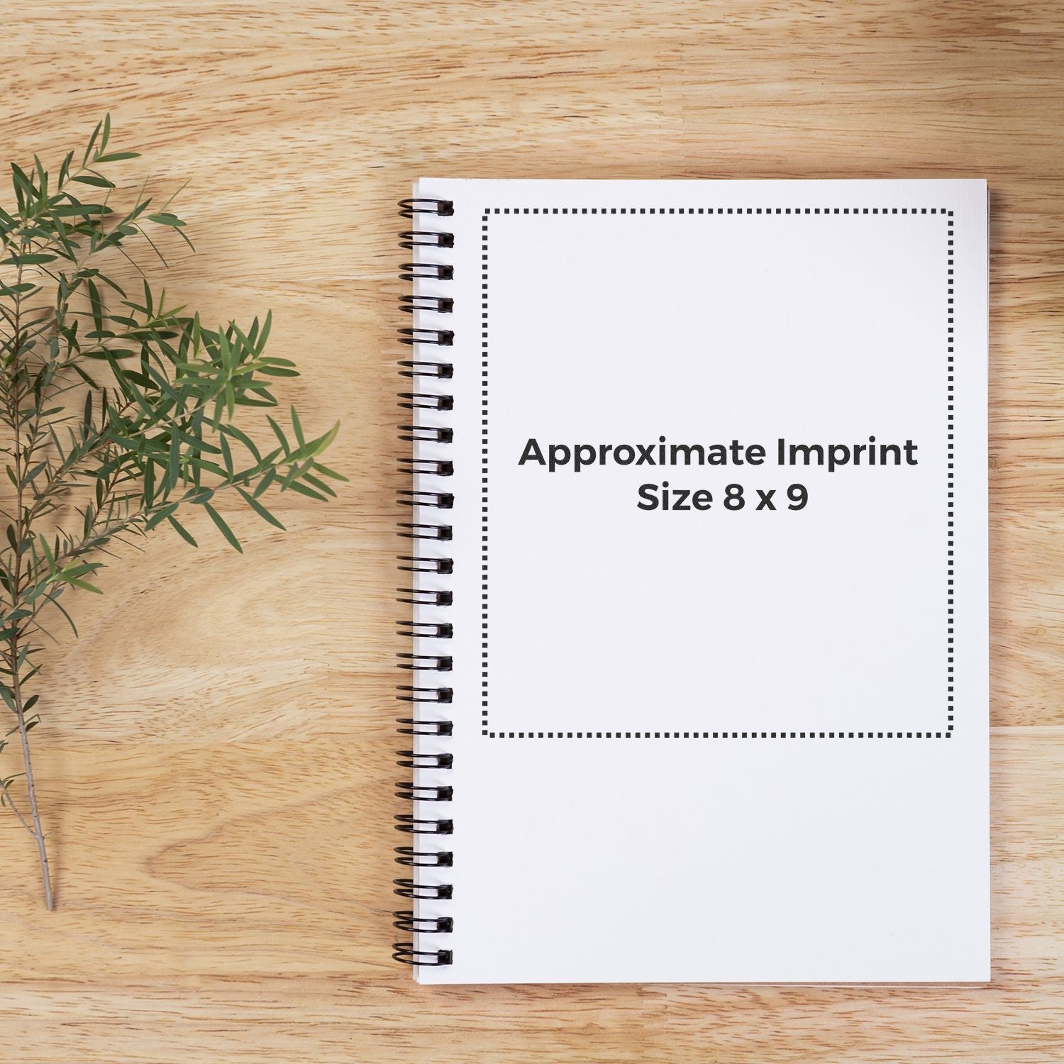 Custom Rubber Stamp Size 8 x 9 displayed on a spiral notebook with a wooden background and a small green plant on the left.