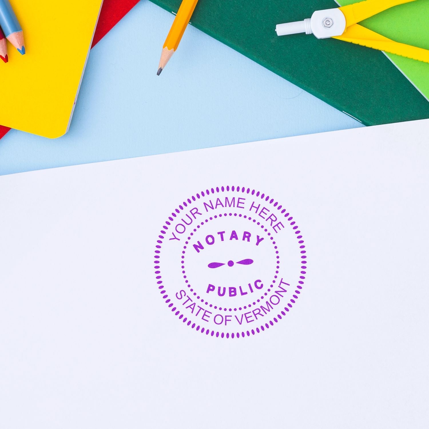 MaxLight Pre-Inked Stamp of Notary Public Seal in purple ink on white paper, surrounded by colorful stationery items.