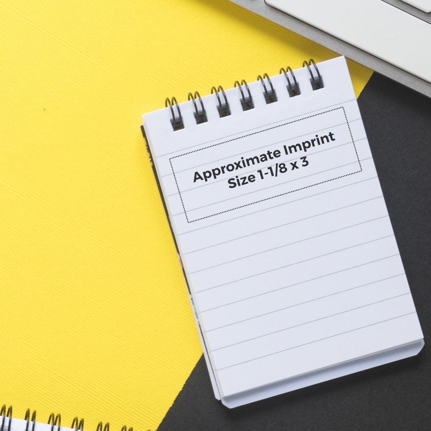 Slim Pre-Inked Original Document Stamp on a spiral notepad with Approximate Imprint Size 1-1/8 x 3 text, placed on a yellow and black background.