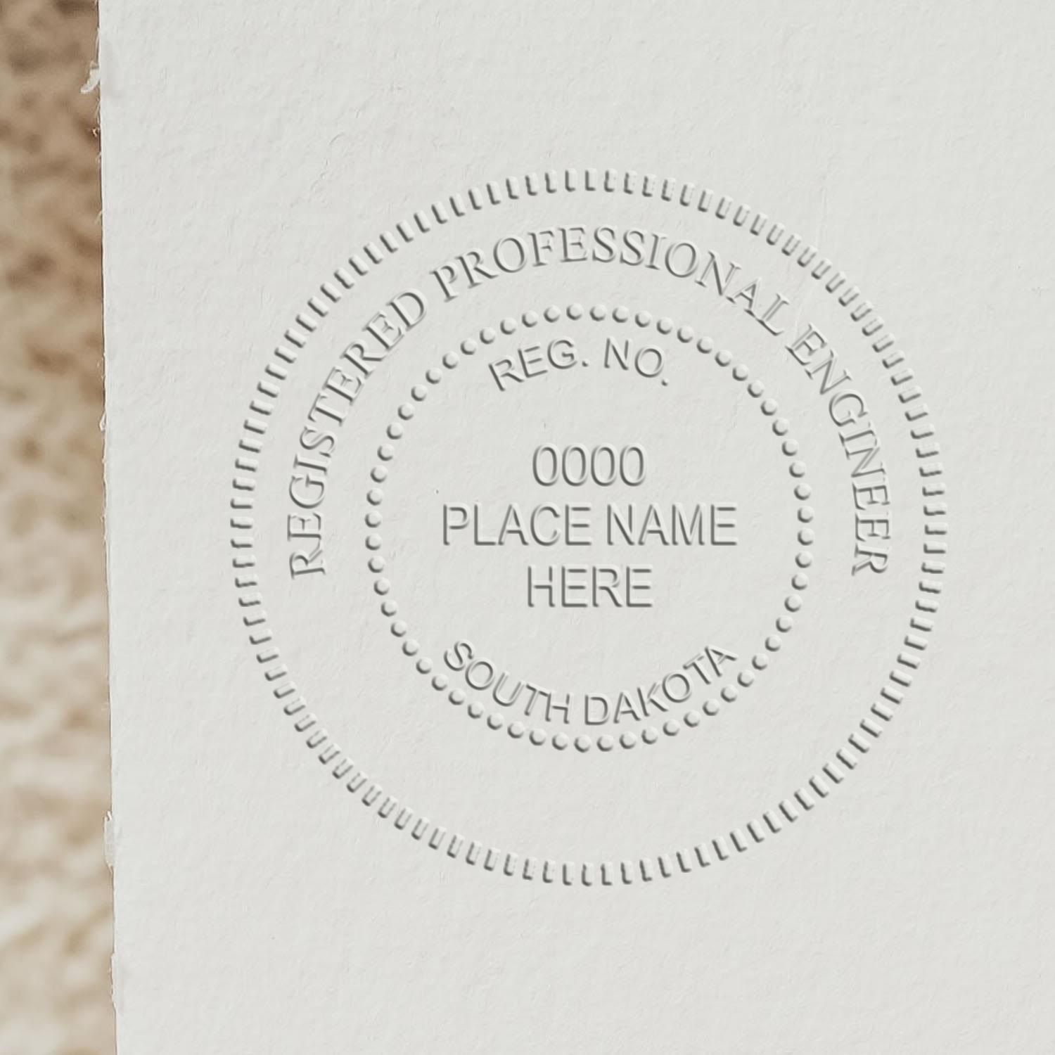 A lifestyle photo showing a stamped image of the Handheld South Dakota Professional Engineer Embosser on a piece of paper