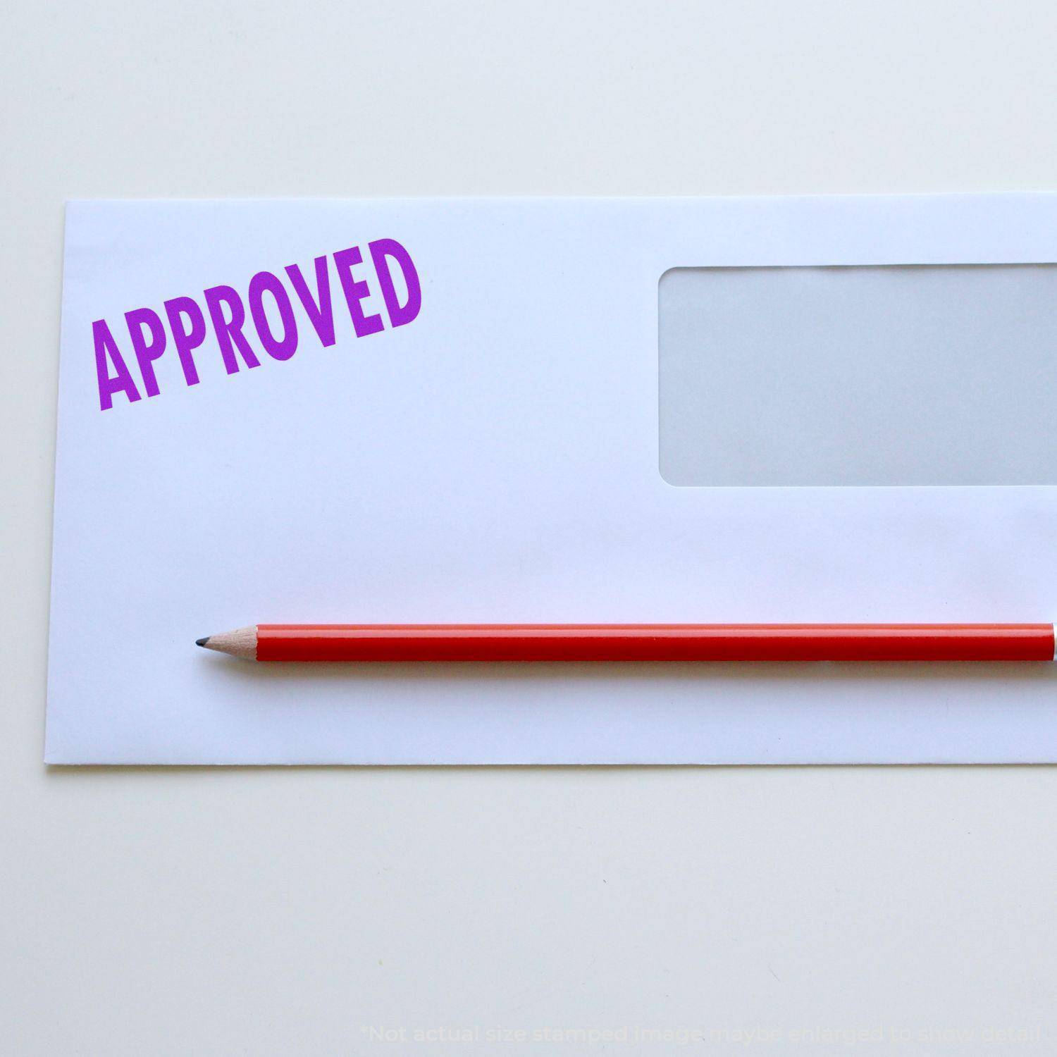 Envelope stamped with APPROVED in purple ink using the Large Self Inking Approved Stamp, with a red pencil placed on top.