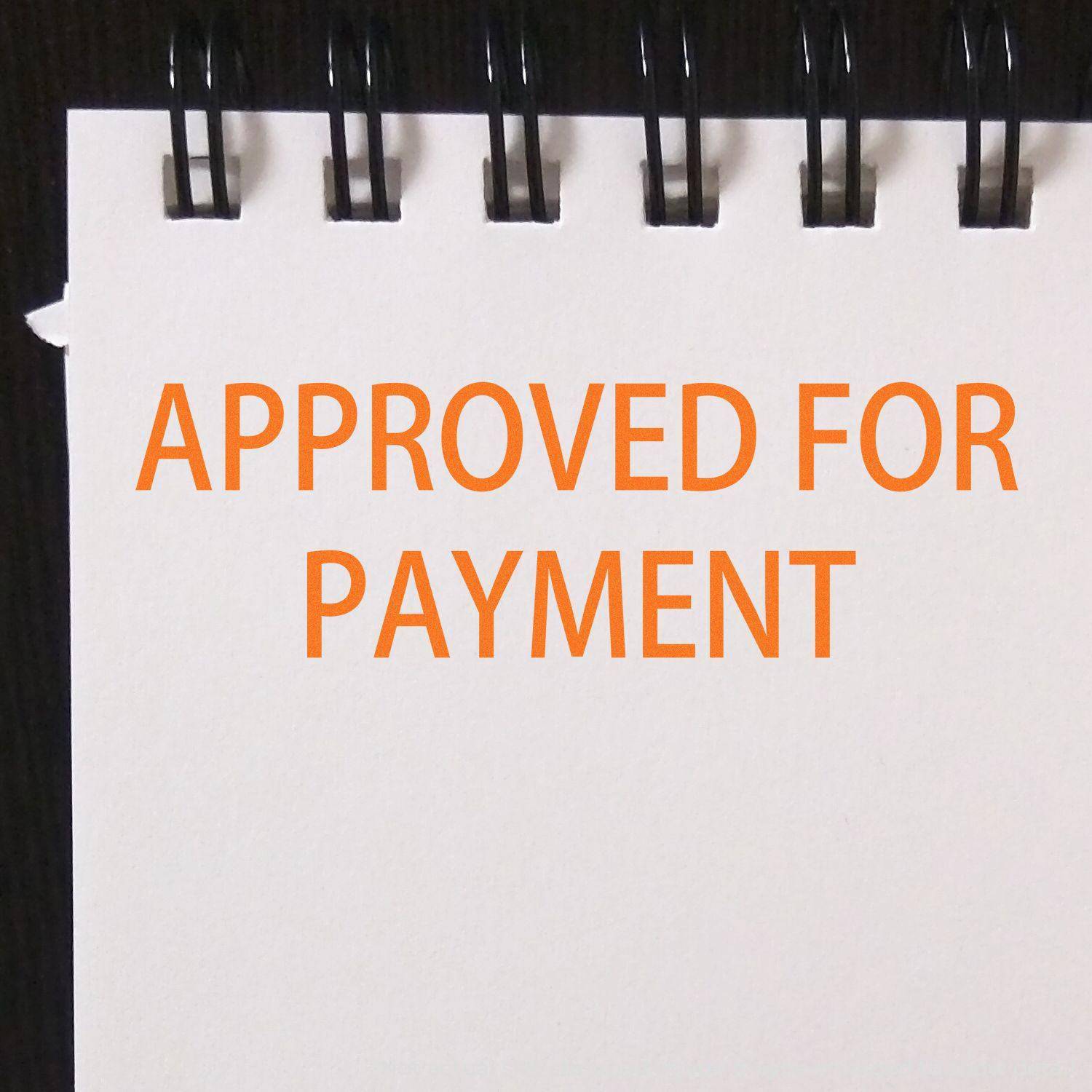 A notebook with APPROVED FOR PAYMENT stamped in orange using the Large Pre-Inked Approved For Payment Stamp.