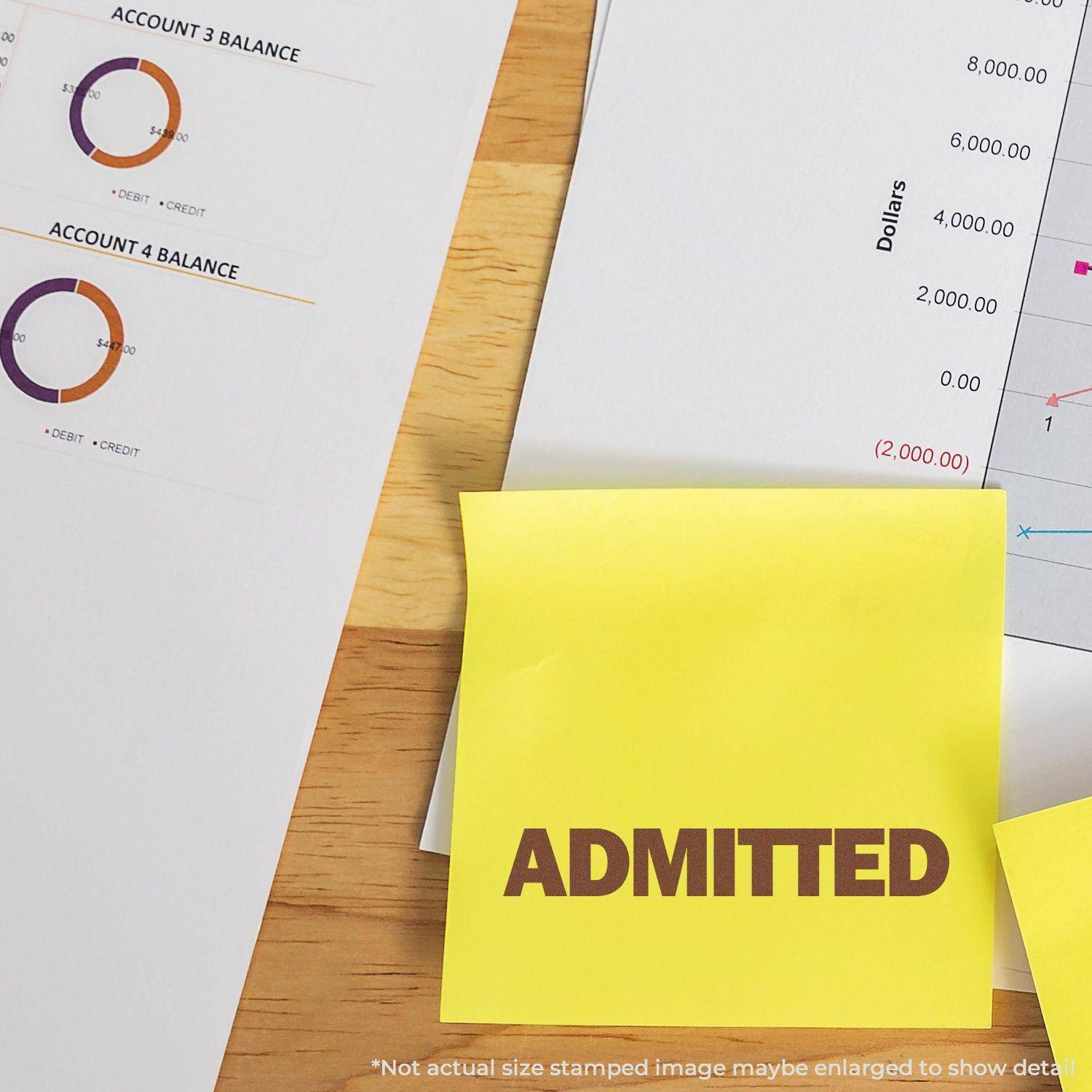 Large Self Inking Bold Admitted Stamp used on a yellow sticky note, placed on a desk with financial documents and charts.
