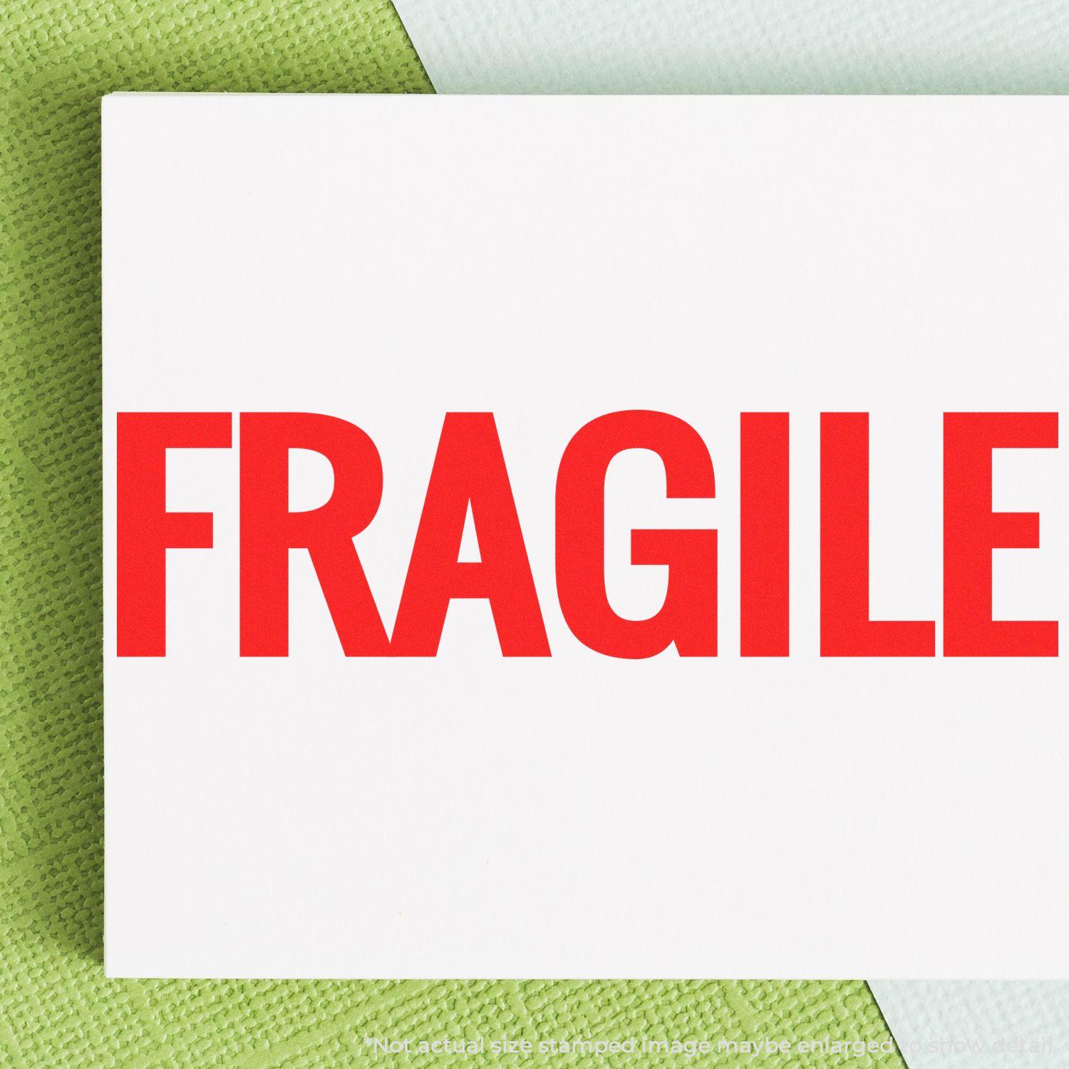 A stock office pre-inked stamp with a stamped image showing how the text "FRAGILE" in bold font is displayed after stamping.