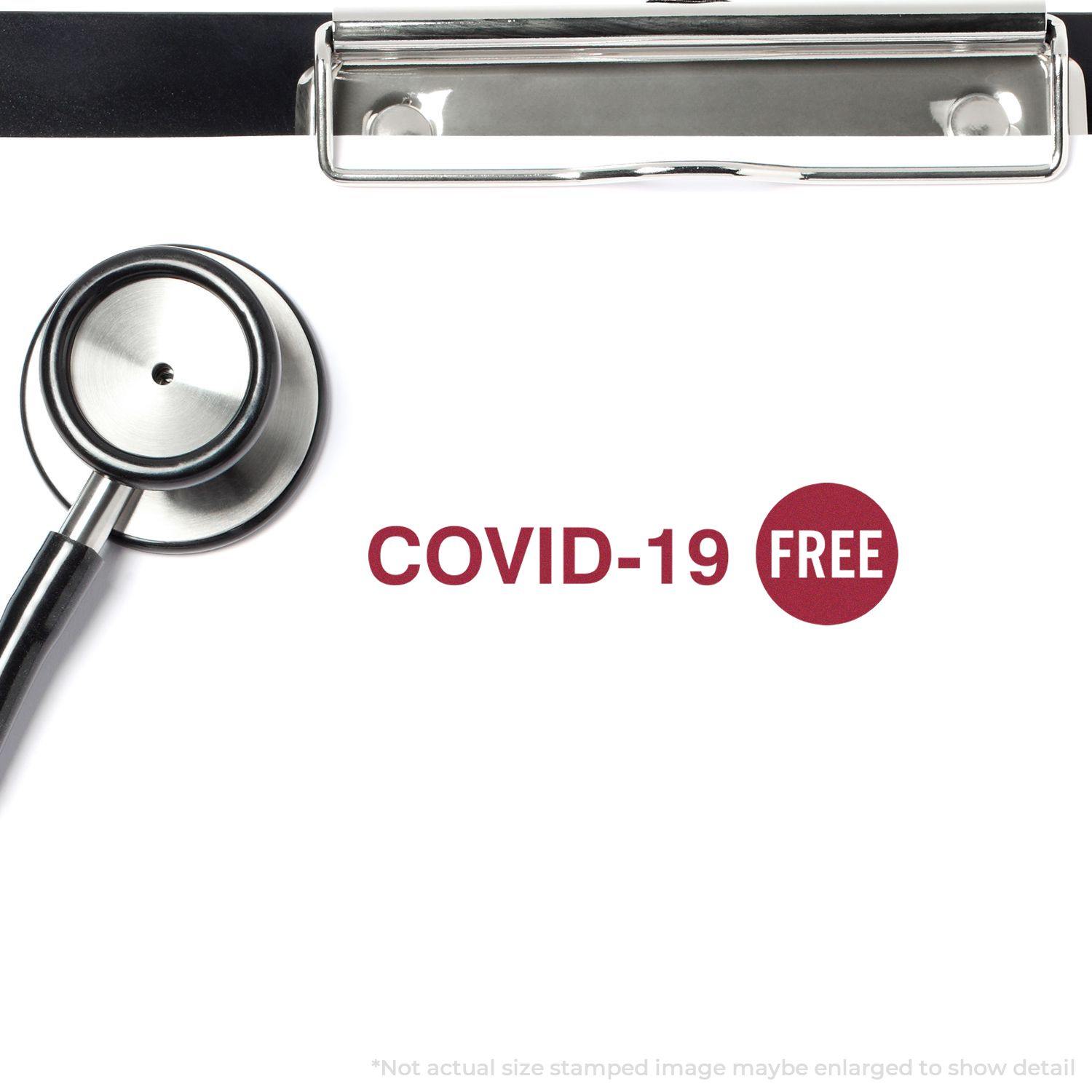 Slim Pre-Inked Covid-19 Stamp marks COVID-19 FREE in red on a white paper with a stethoscope and clipboard nearby.