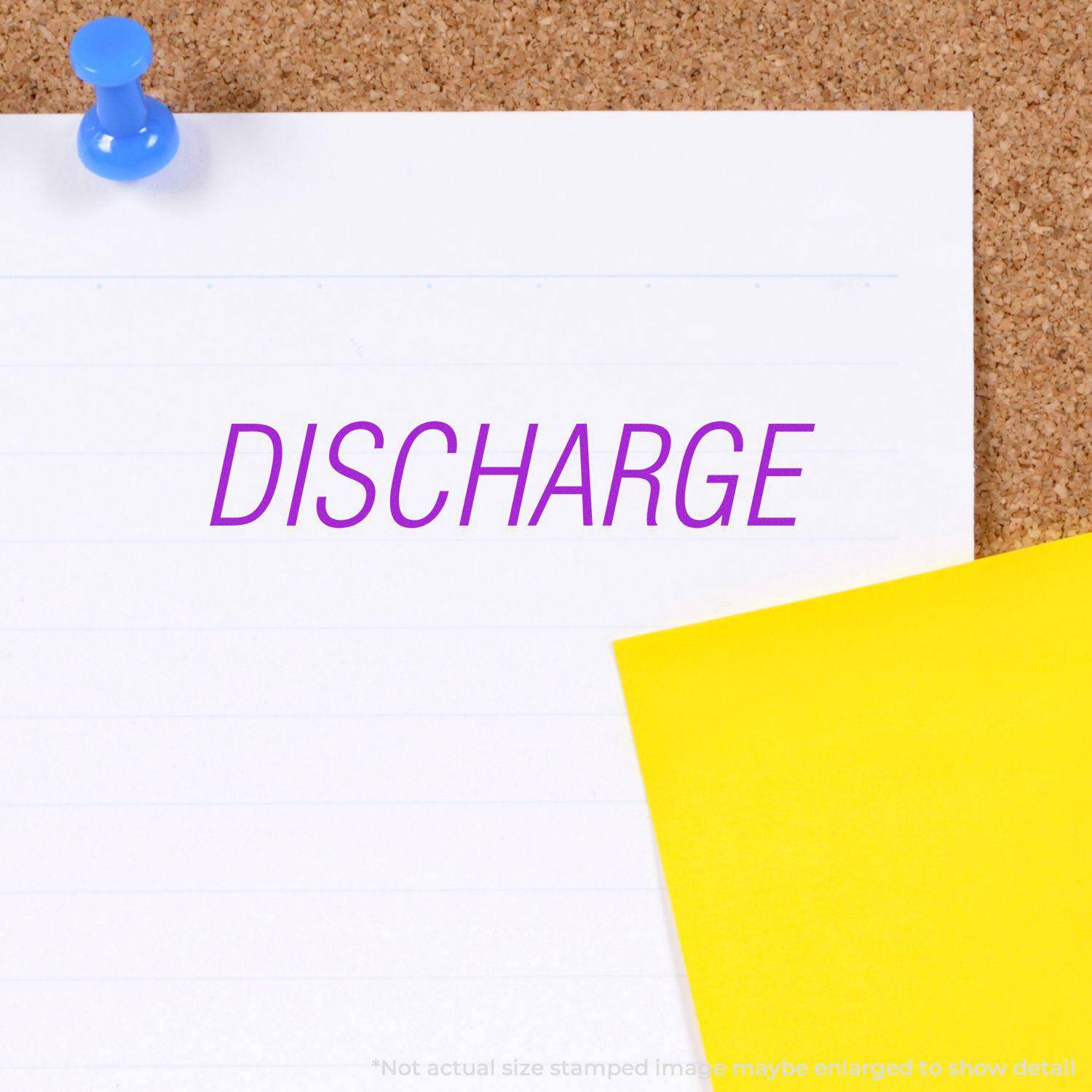 Large Pre-Inked Discharge Stamp used on white paper pinned to a corkboard, with a yellow sticky note nearby.