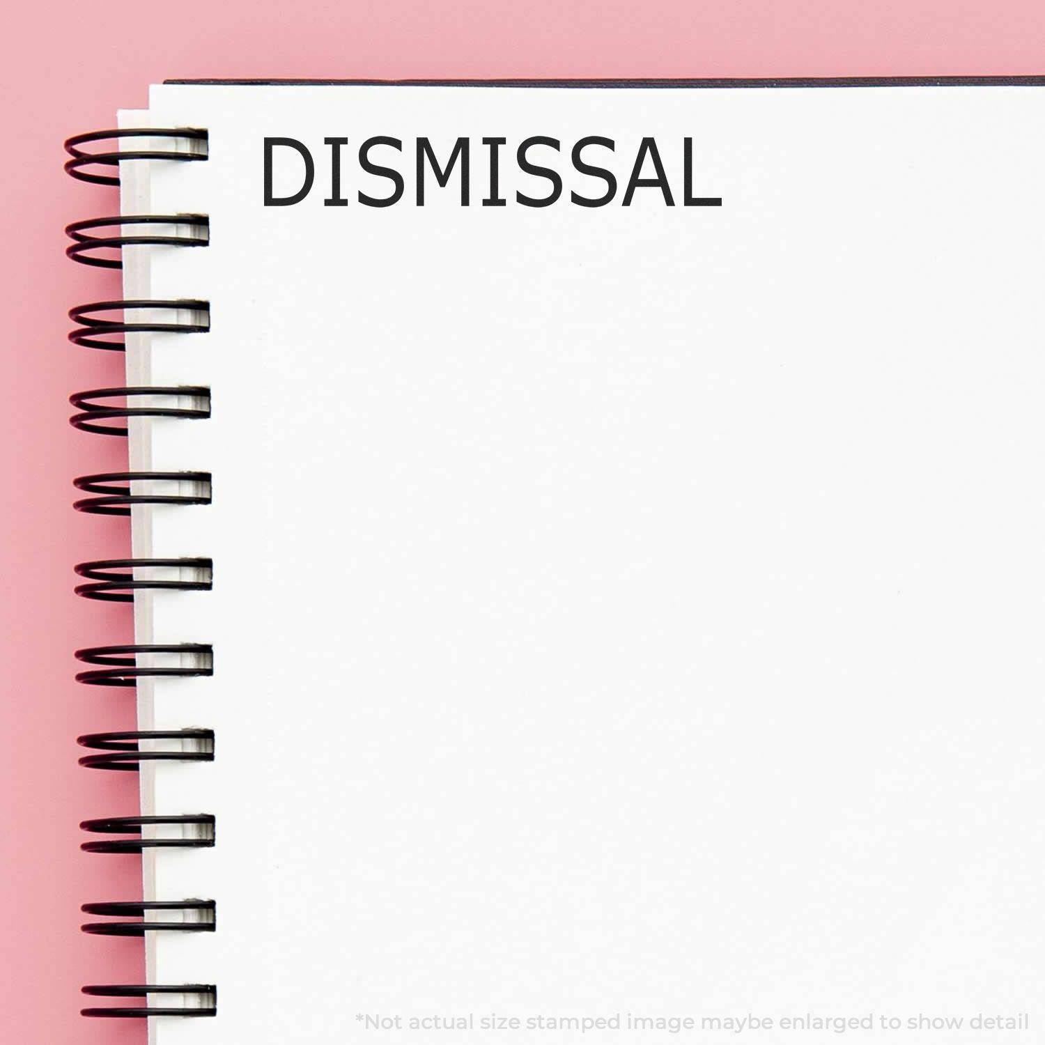 Large Pre-Inked Dismissal Stamp used on a white spiral notebook, showing the word DISMISSAL in bold black letters on a pink background.