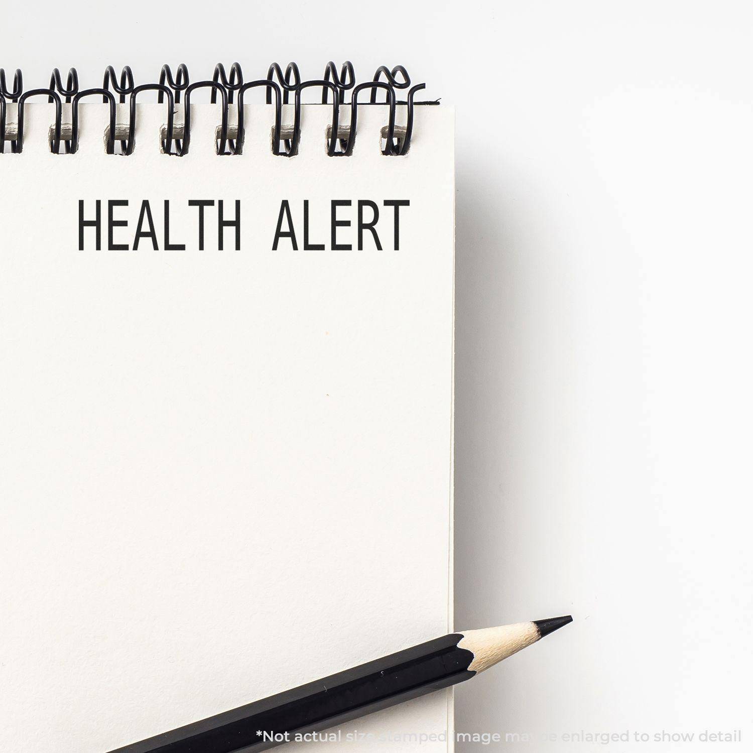 Large Pre-Inked Health Alert Stamp used on a white notepad with a pencil beside it, displaying the text 'HEALTH ALERT' in bold letters.
