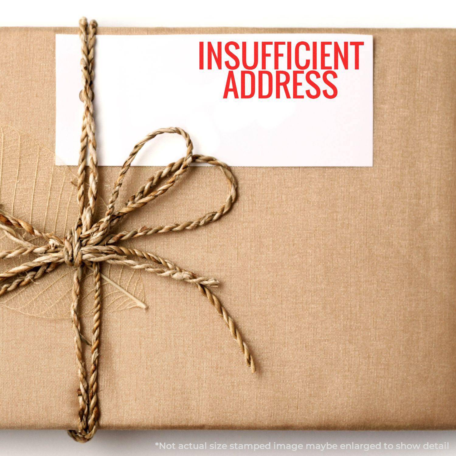 A package wrapped in brown paper with a card stamped INSUFFICIENT ADDRESS using the Large Pre-Inked Insufficient Address Stamp.
