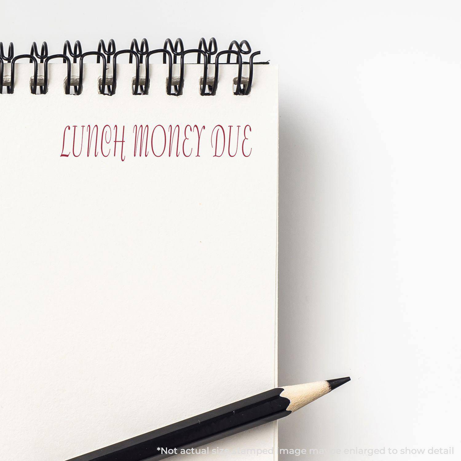 Notepad with LUNCH MONEY DUE stamped in red using the Large Pre-Inked Lunch Money Due Stamp, with a pencil beside it.