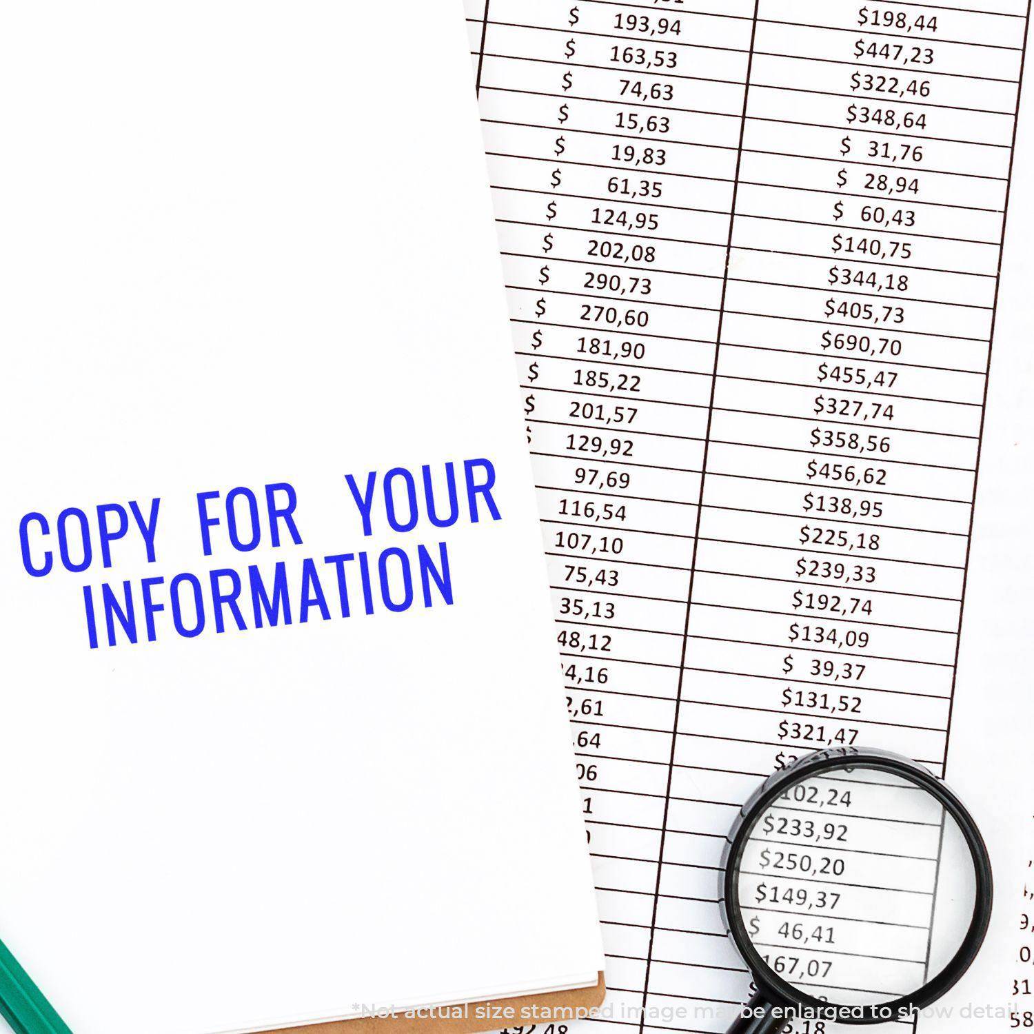 Large Pre-Inked Narrow Copy for your Information Stamp used on a document with financial data, magnifying glass, and pen nearby.