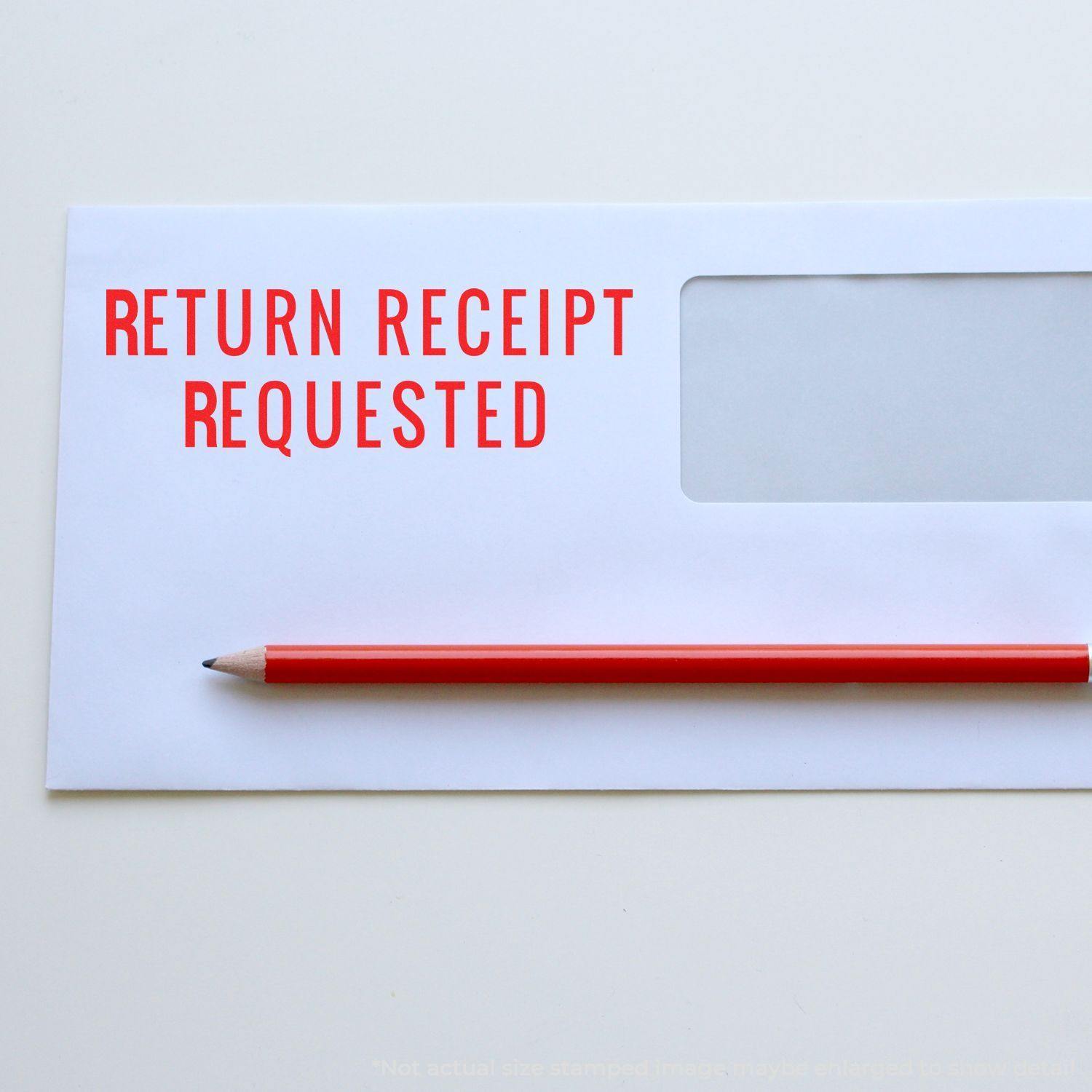 Large Narrow Font Return Receipt Requested Self Inking Stamp used on a white envelope with a red pencil placed on top.