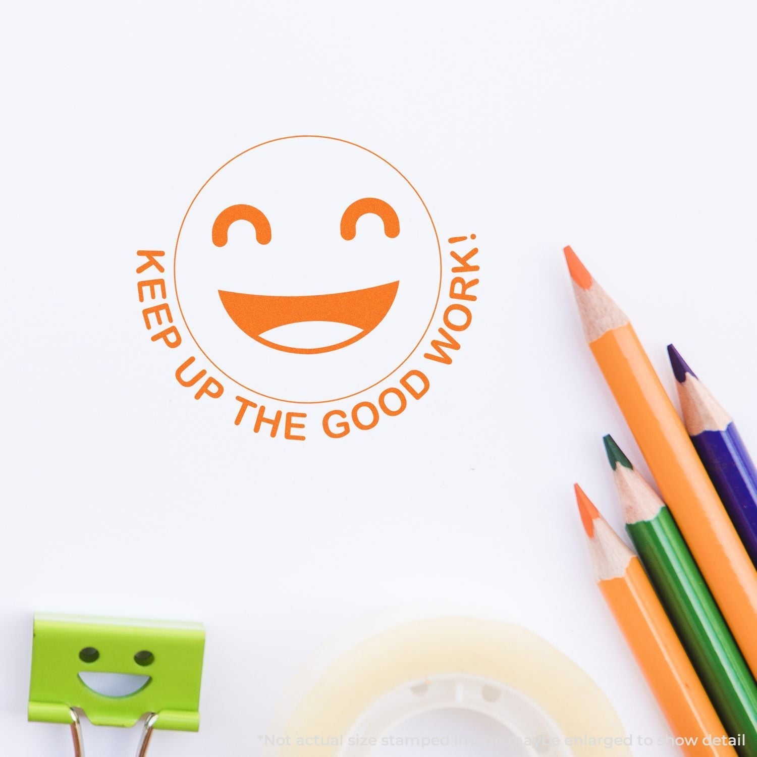 Self Inking Round Keep up the Good Work Smiley Stamp in orange ink on white paper, surrounded by colorful pencils and a smiley clip.