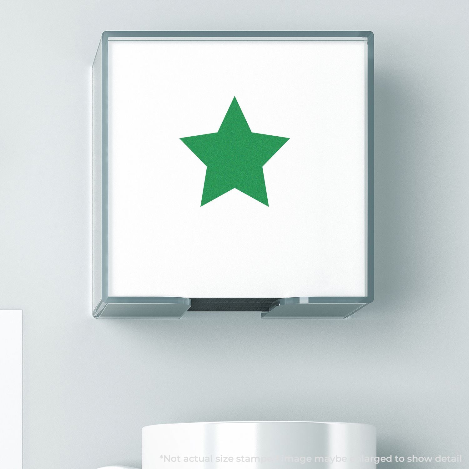 Self Inking Round Solid Star Stamp with a green star imprint on a white surface, shown in use above a white mug.