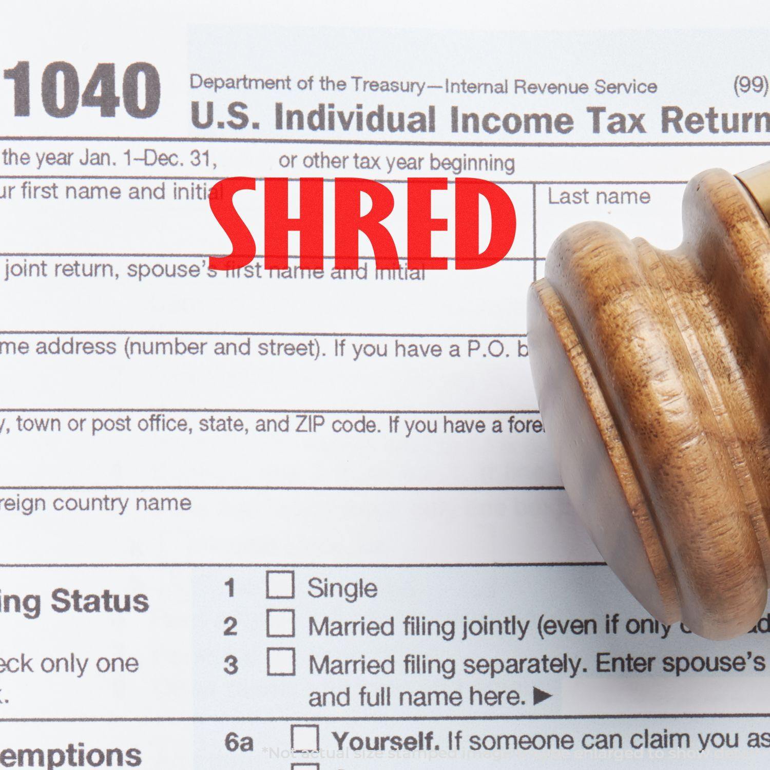 Large Shred Rubber Stamp in red ink on a U.S. Individual Income Tax Return form, with a wooden stamp handle visible.