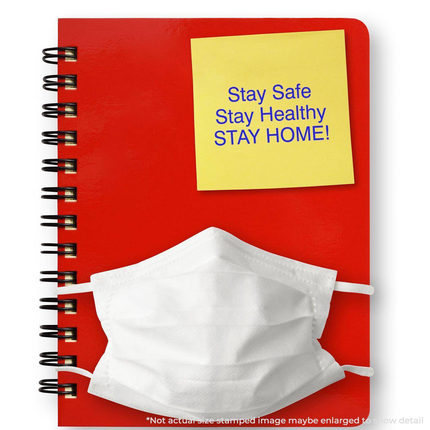 Red notebook with a white mask and a yellow sticky note stamped with Stay Safe Stay Healthy Stay Home! using the Large Pre-Inked Stay Safe Stay Healthy Stamp.