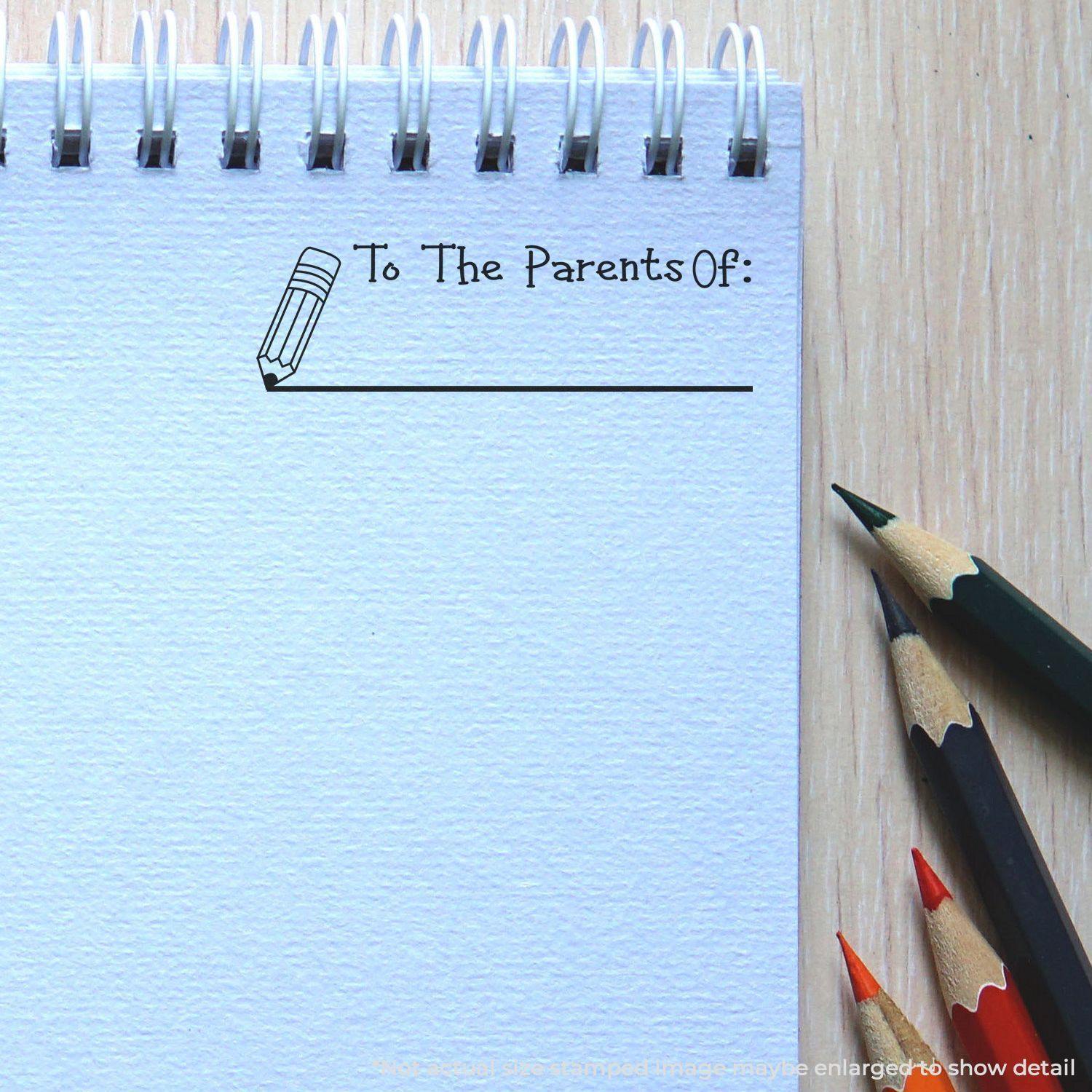 A self-inking stamp with a stamped image showing how the text "To The Parents Of:" with an image of a pencil next to the line is displayed after stamping.
