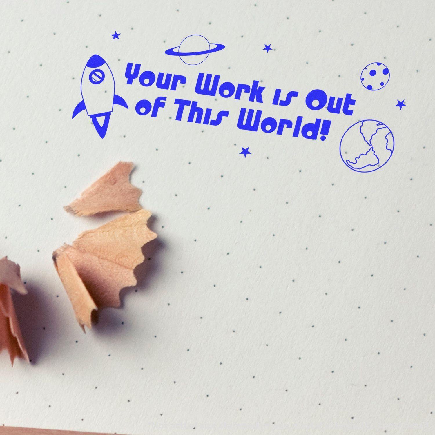 Blue Self Inking Your Work is Out of This World Stamp on dotted paper with pencil shavings nearby.
