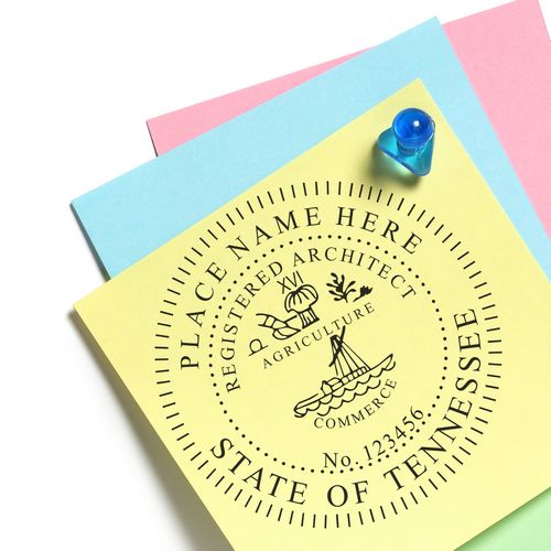 Self Inking Tennessee Architect Stamp on yellow paper with blue and pink sheets in the background, secured by a blue pushpin.