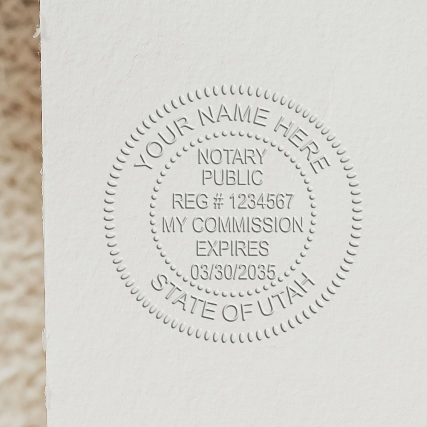 Utah Handheld Notary Seal Embosser imprint on white paper showing a circular notary seal with customizable text, registration number, and expiration date.