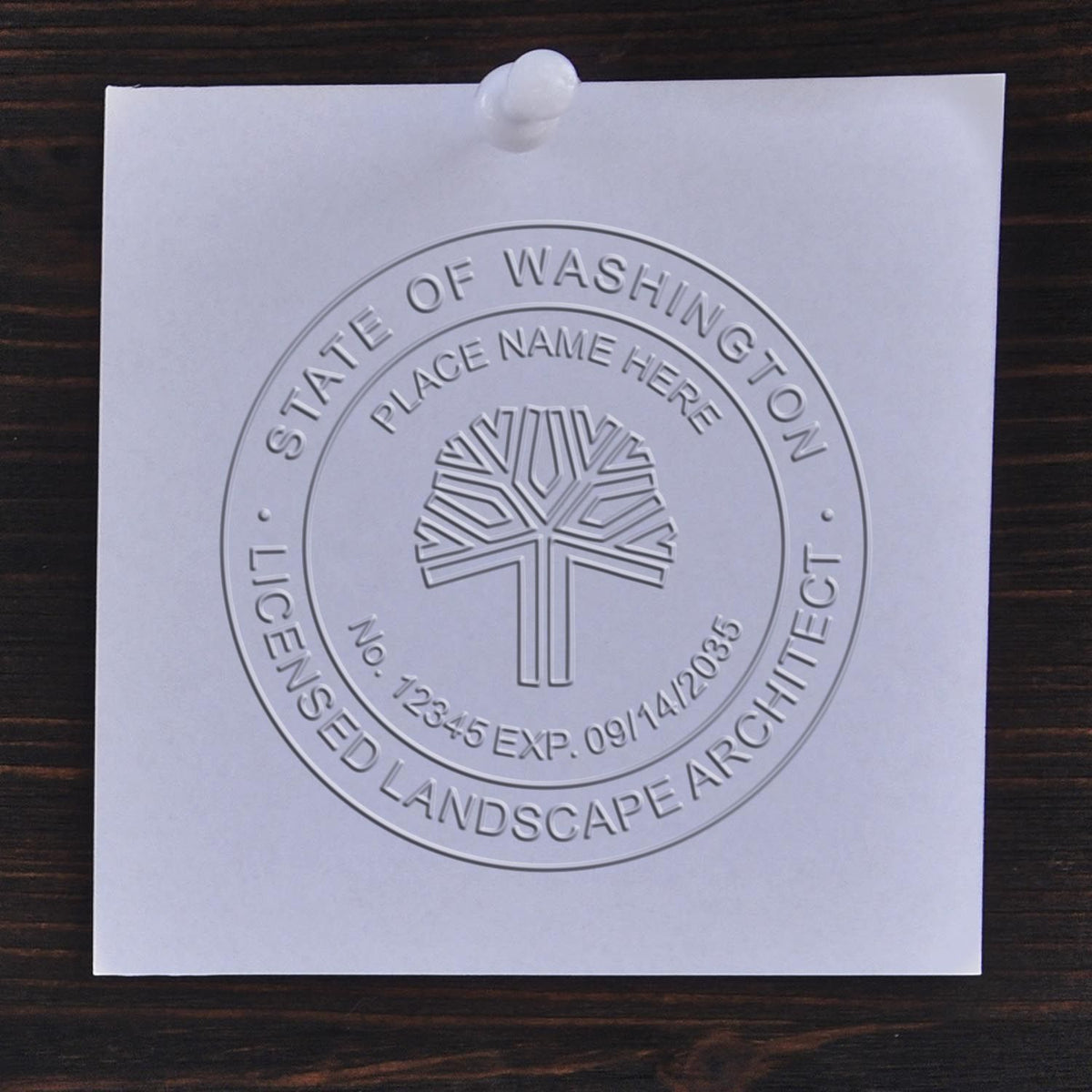 An in use photo of the Hybrid Washington Landscape Architect Seal showing a sample imprint on a cardstock
