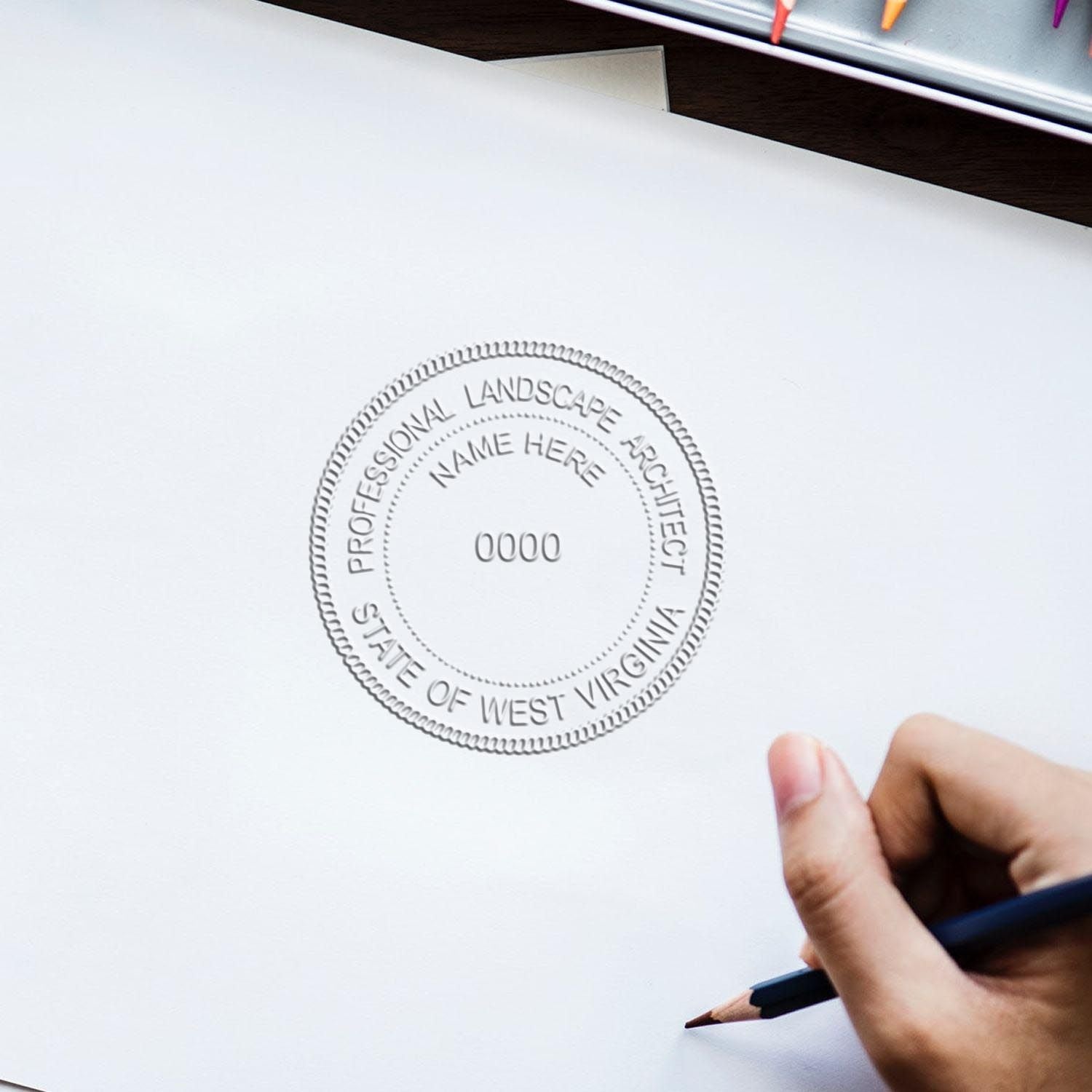 Shiny West Virginia landscape architect embossing stamp in use, showcasing detailed state design on paper.