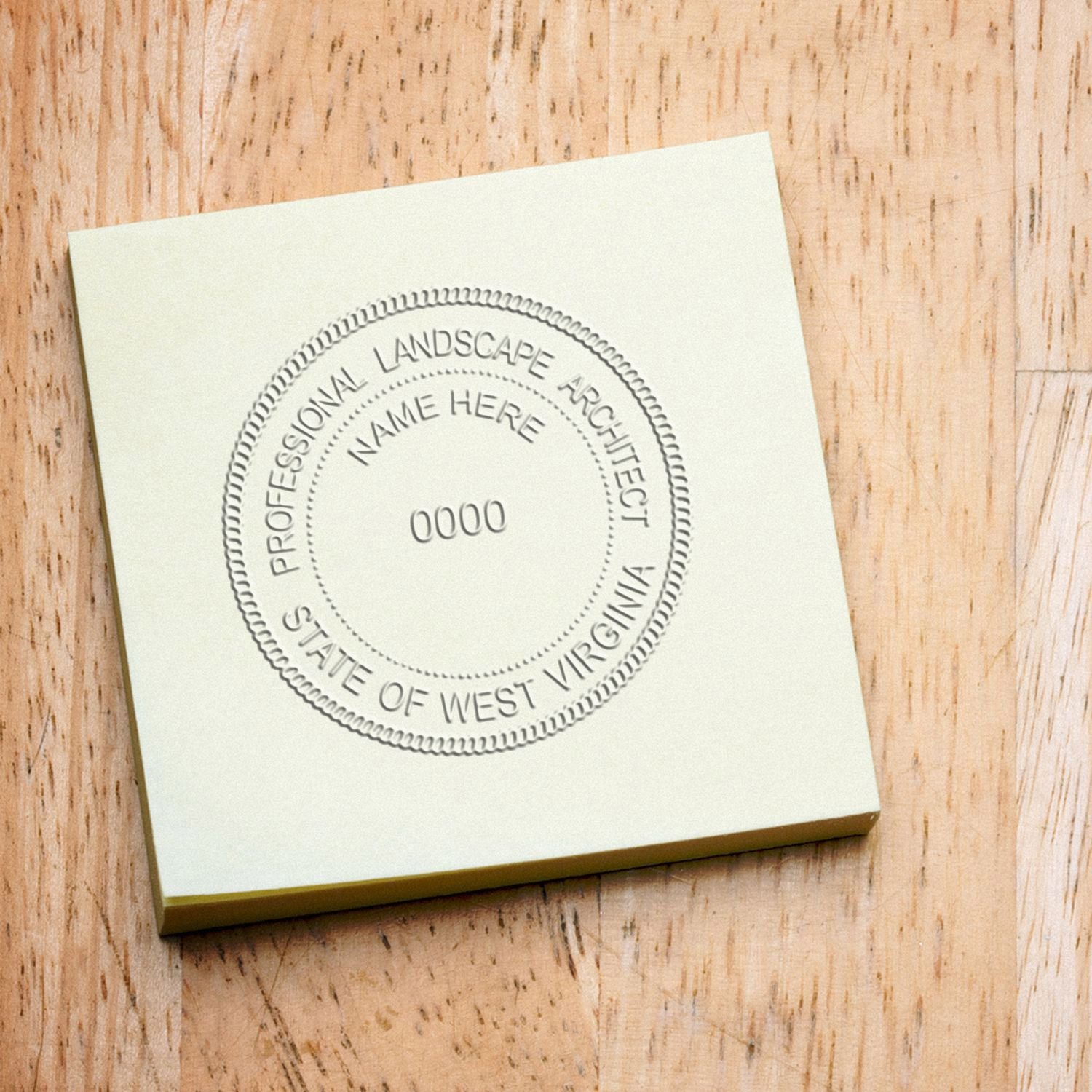 Shiny West Virginia landscape architect embossing stamp in use, showing detailed state outline and landscape design on paper.