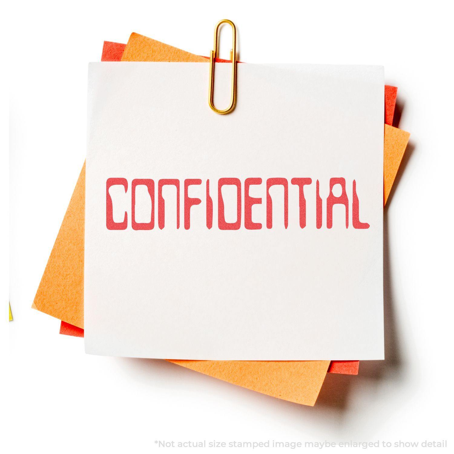 A paper stamped with CONFIDENTIAL using the Barcode Confidential Xstamper Stamp, clipped with a gold paperclip to orange and yellow papers.