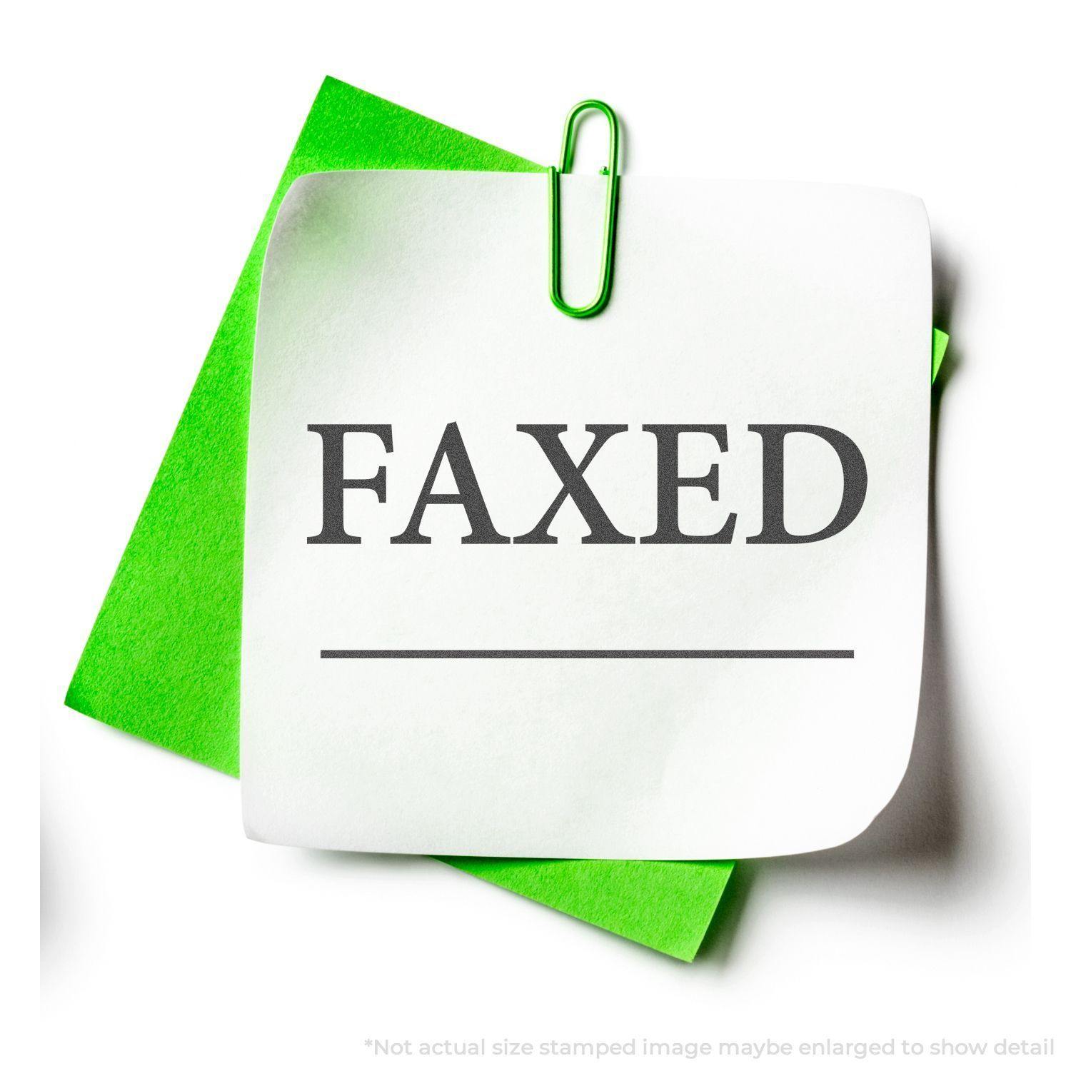 A green paperclip holds a white paper with FAXED stamped on it using the Black Faxed Xstamper Stamp, placed on a green background.