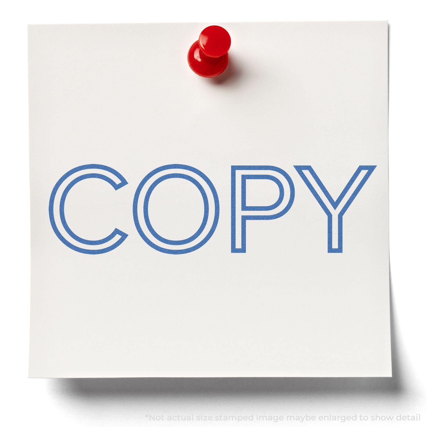 Blue Copy Xstamper Stamp imprint on a white note pinned with a red pushpin. The word COPY is stamped in blue ink.