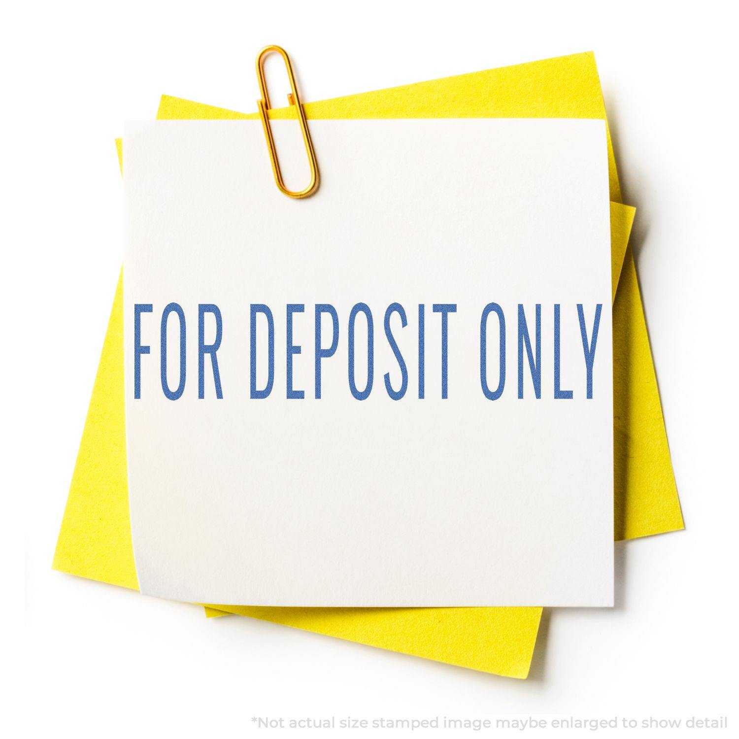 Blue For Deposit Only Xstamper Stamp imprint on white paper with a yellow background and a paperclip.