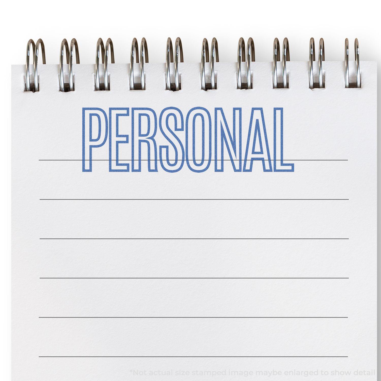 Blue Personal Xstamper Stamp imprinting the word PERSONAL in blue ink on a white spiral notebook with lined pages.