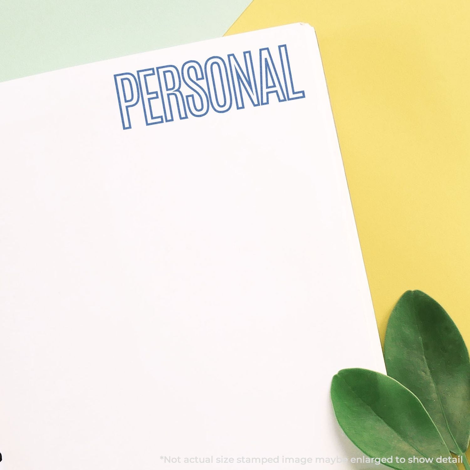 Slim Stamp 1444 Customized Pre-Inked Stamp 1/2 x 1-3/4 used to stamp PERSONAL in blue on white paper with green leaves nearby.