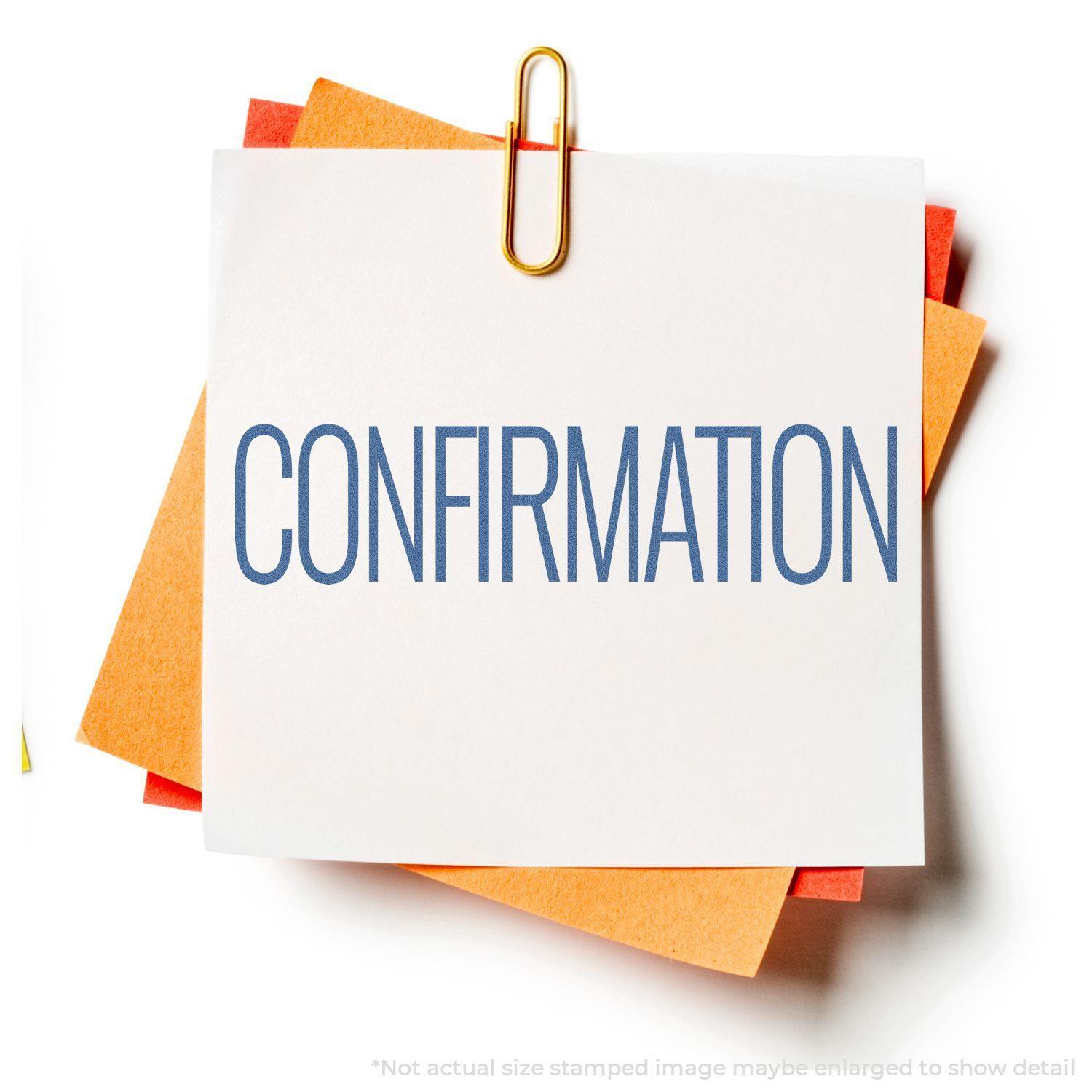 Confirmation Xstamper Stamp imprint on a white paper clipped to orange papers, showcasing the word CONFIRMATION in blue text.