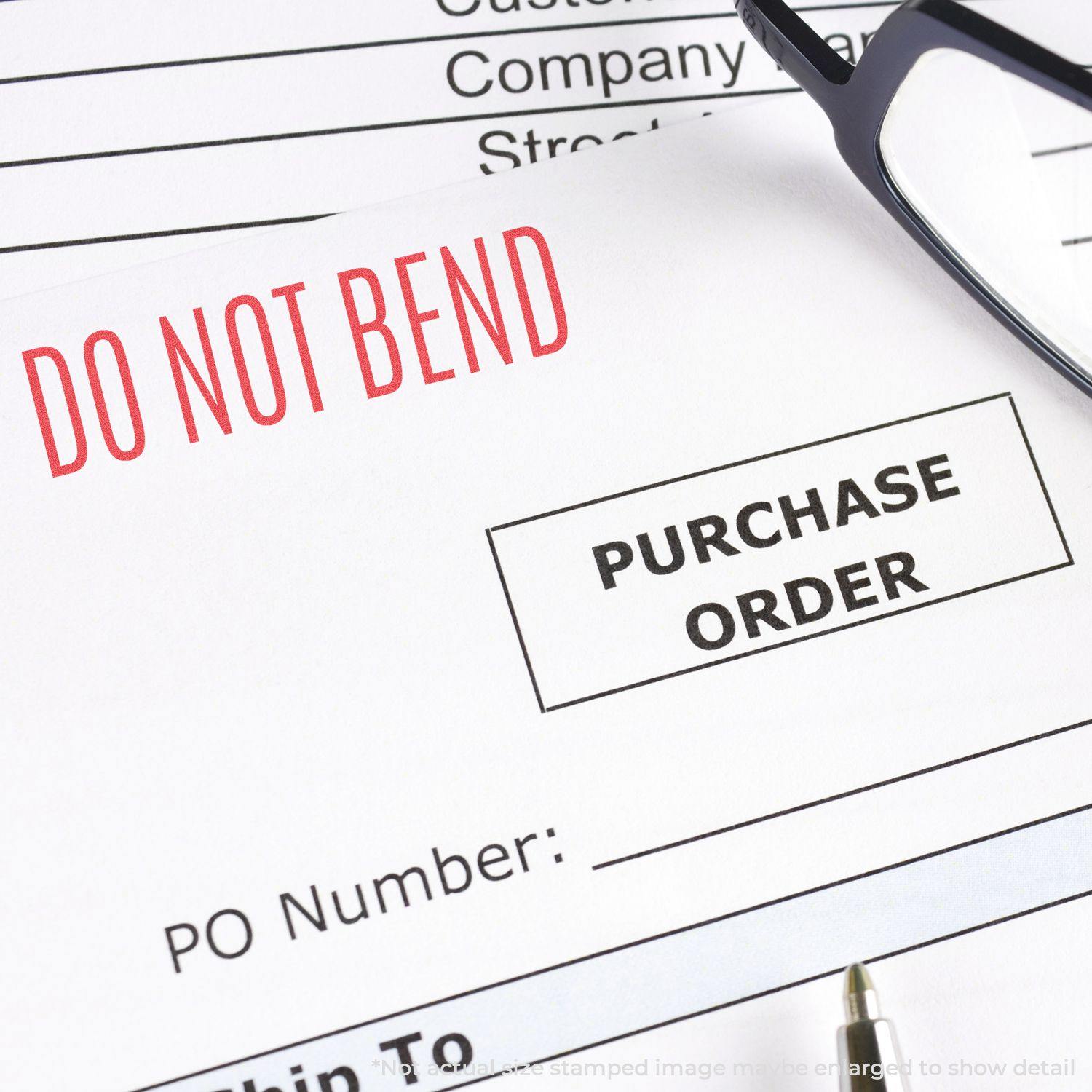 Close-up of a purchase order stamped with DO NOT BEND using the Do Not Bend Xstamper Stamp, with glasses and a pen nearby.