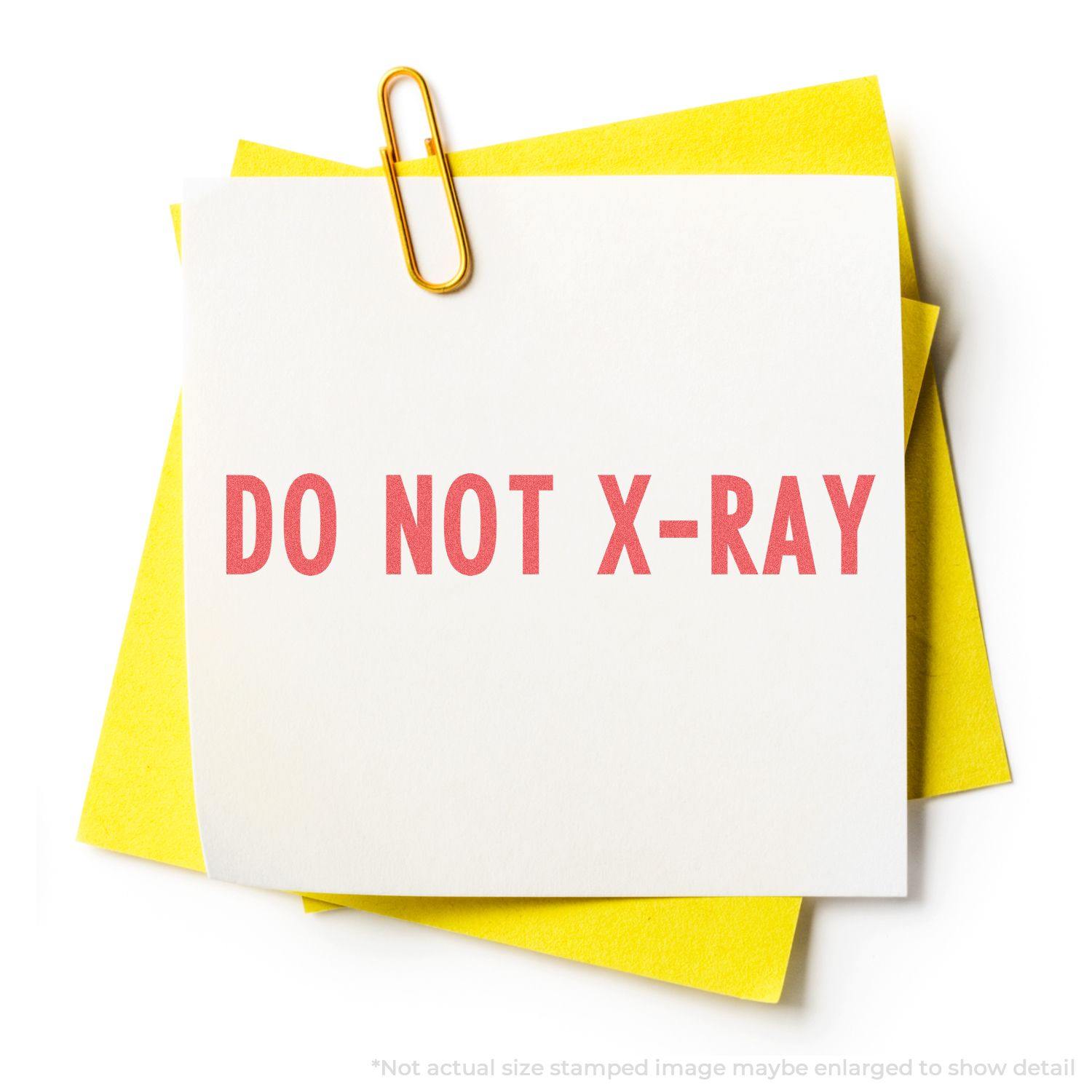 A yellow paper clip holds a white note with DO NOT X-RAY stamped in red using the Do Not X-Ray Xstamper Stamp.