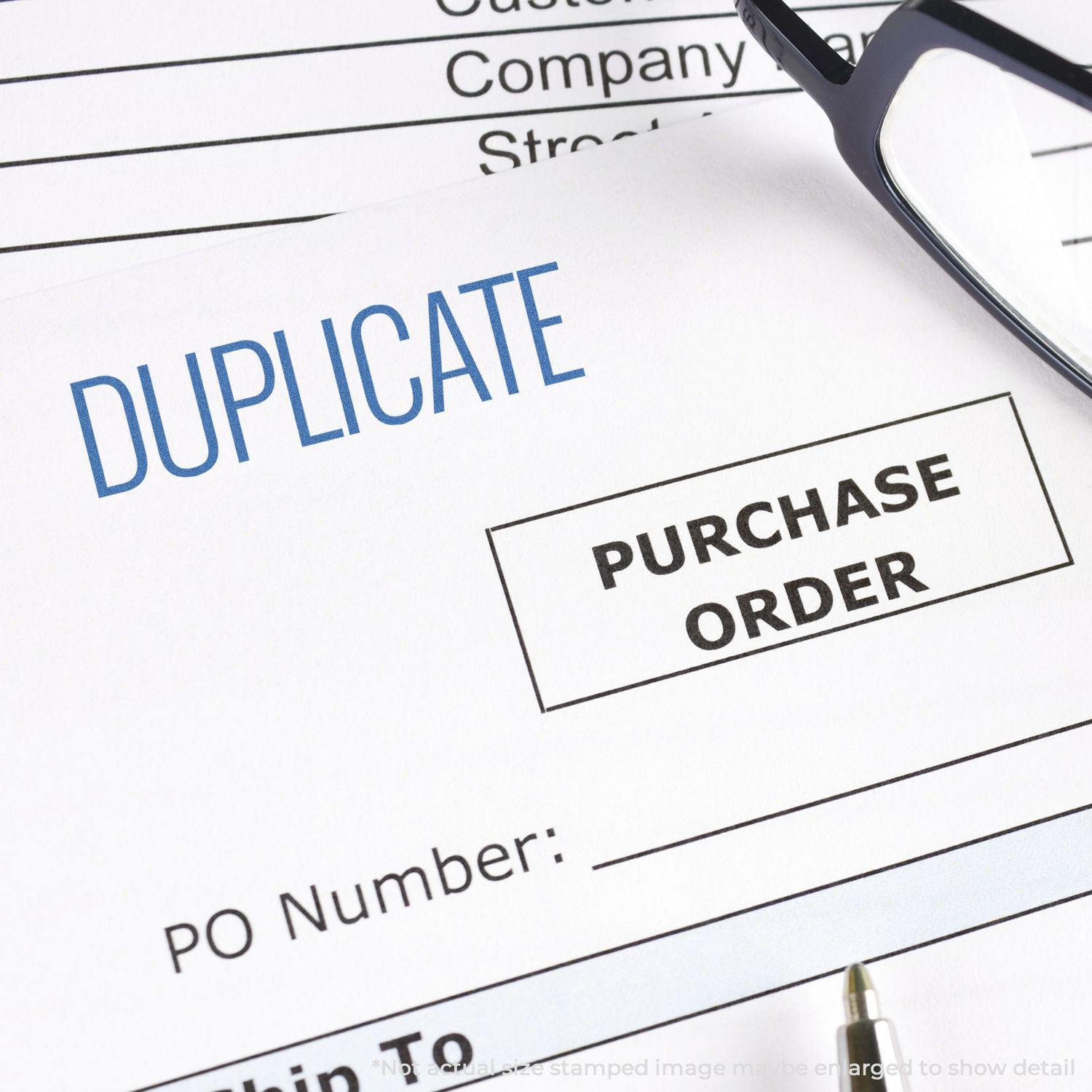 Duplicate Xstamper Stamp marking DUPLICATE on a purchase order document, with glasses placed nearby.