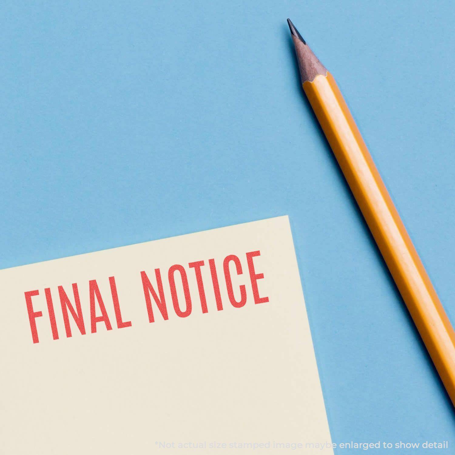 Final Notice Xstamper Stamp imprint in red on a yellow paper, next to a sharpened yellow pencil on a blue background.