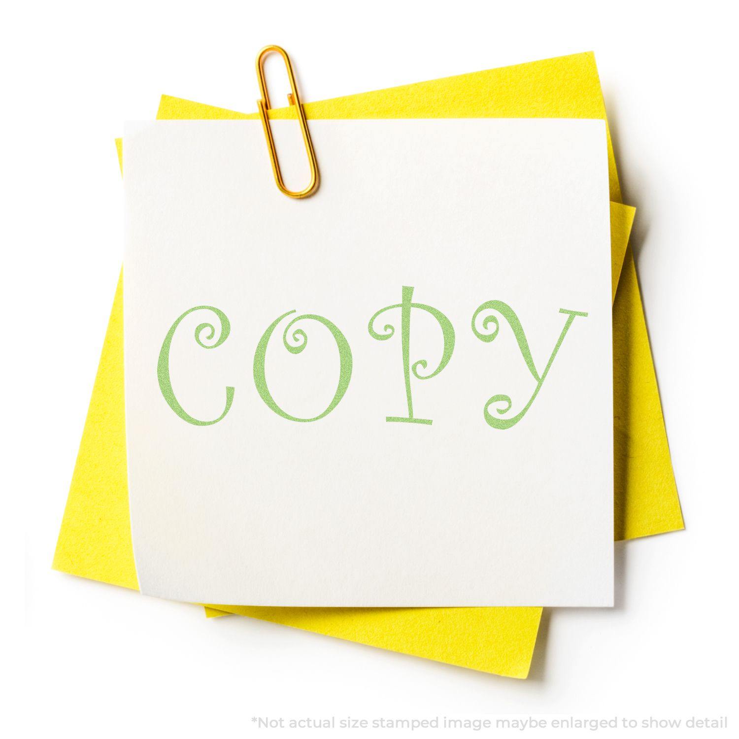 Green Copy Xstamper Stamp imprint on white paper with yellow sheets underneath, held together by a gold paperclip.