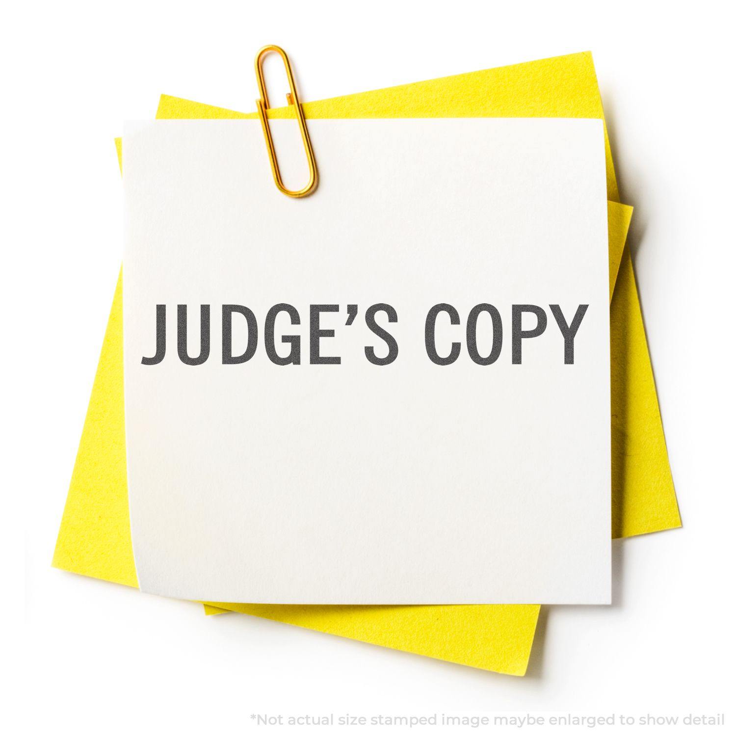 Judge's Copy Xstamper Stamp impression on a white paper clipped to yellow sheets, displaying the text JUDGE'S COPY in bold letters.