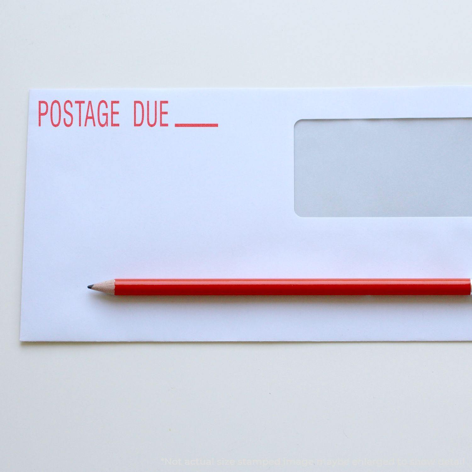 Envelope stamped with POSTAGE DUE using a Postage Due Xstamper Stamp, with a red pencil placed on top.