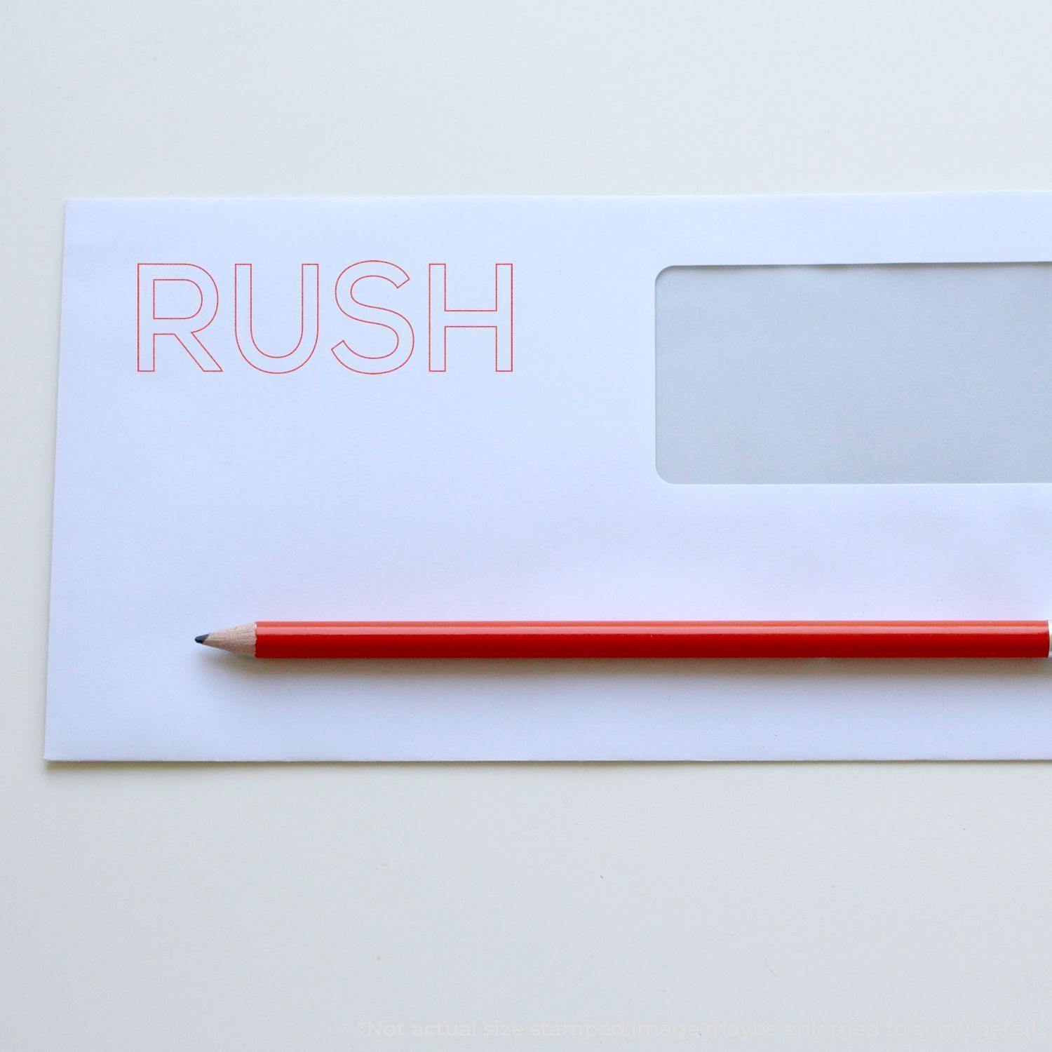 Envelope stamped with RUSH in red ink using the Red Rush Xstamper Stamp, with a red pencil placed diagonally across the envelope.