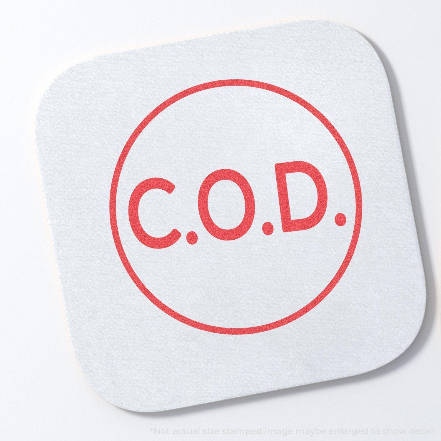 Round C.O.D. Xstamper Stamp in red ink on a white square paper, displaying the letters C.O.D. within a circular border.