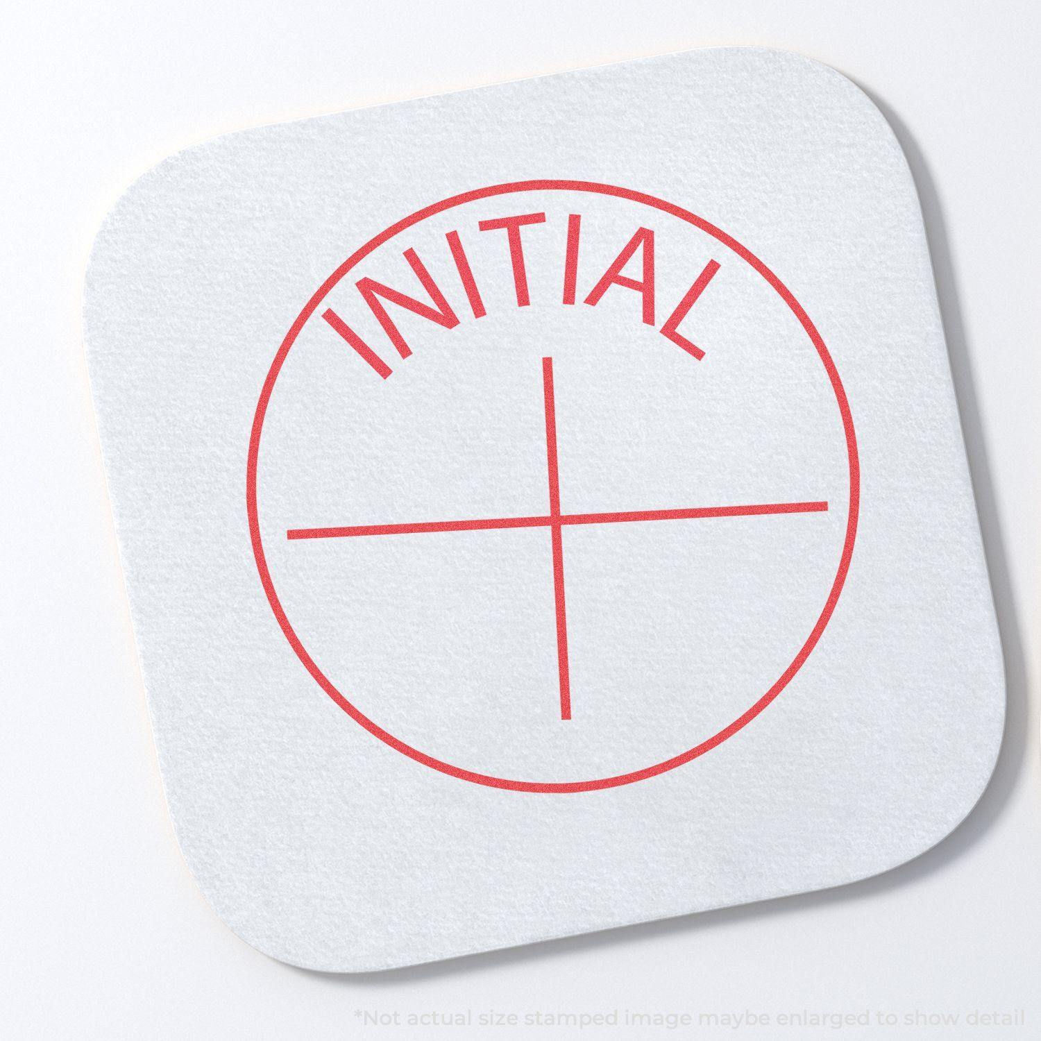 Round Initial Xstamper Stamp imprint in red on a white square paper, showing the word INITIAL above a crosshair.